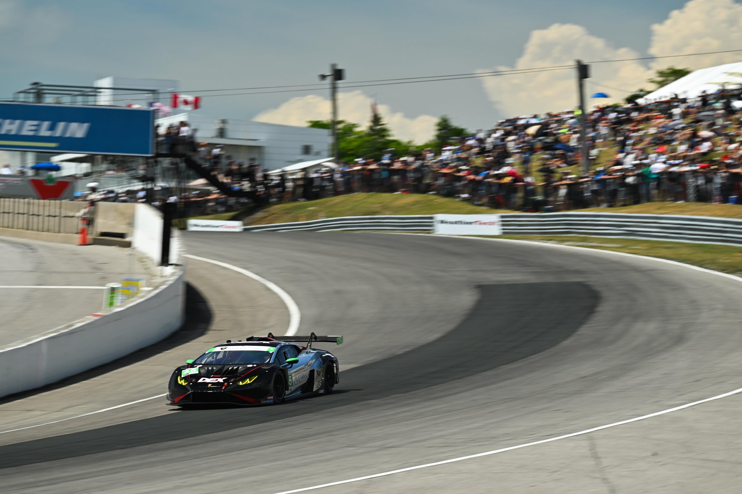 How Wayne Taylor Racing Turned A Cracked Rim And A Lap-One Spin Into Lamborghini'S First Imsa Win Of 2025 11 The #45 lamborghini huracán gt3 evo2 navigating a turn at mosport with spectators visible in the background