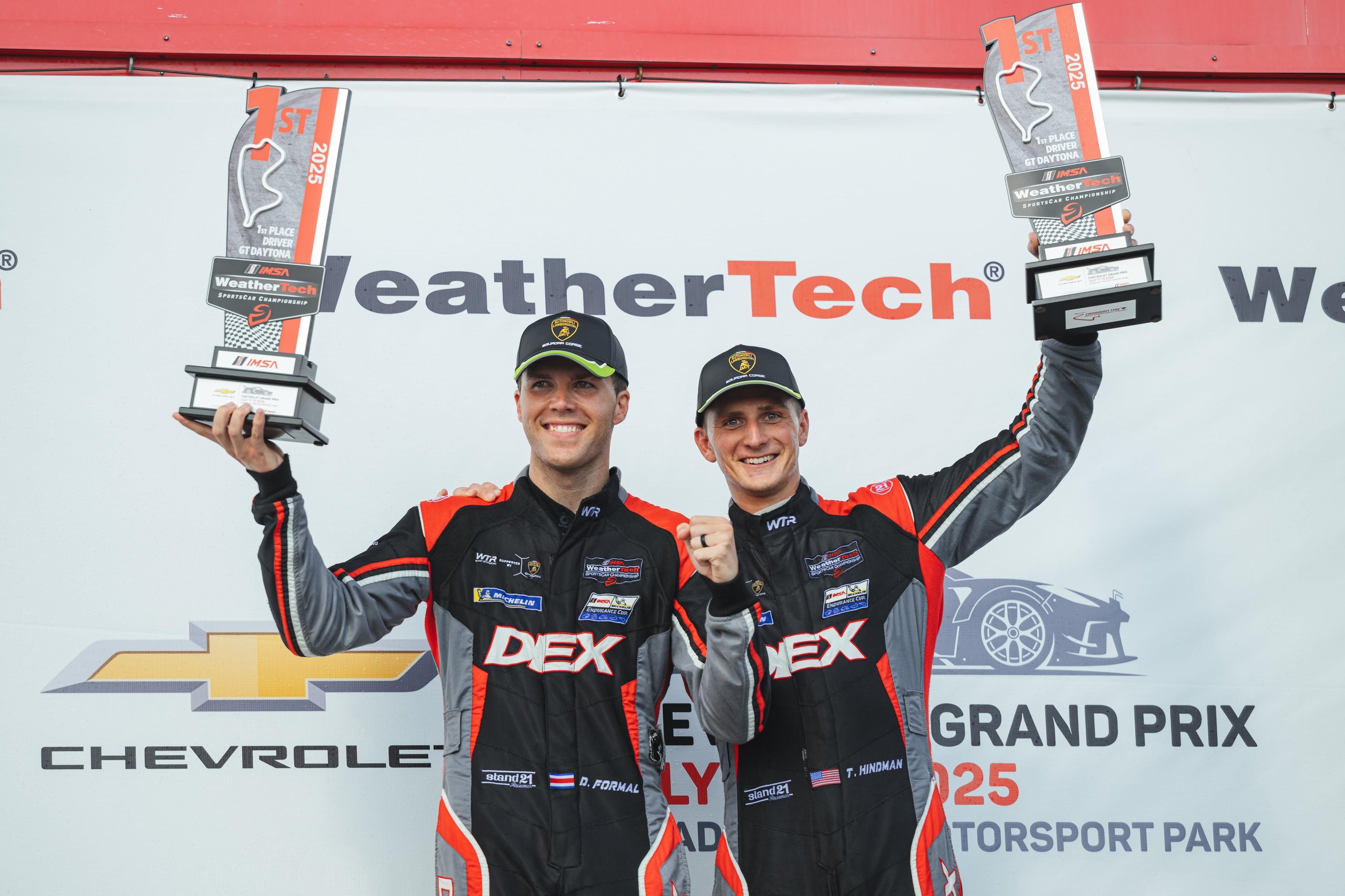 How Wayne Taylor Racing Turned A Cracked Rim And A Lap-One Spin Into Lamborghini'S First Imsa Win Of 2025 7 Danny formal and trent hindman on the mosport podium wearing lamborghini caps and holding their victory trophies