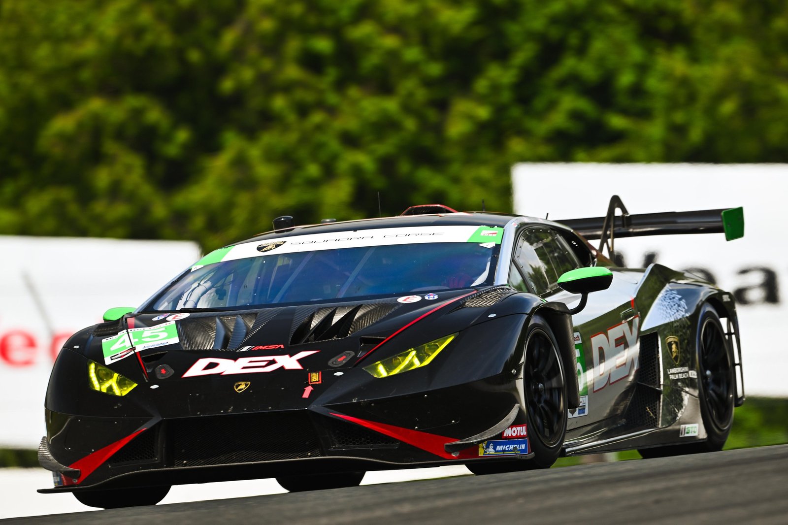 The #45 Wayne Taylor Racing Lamborghini Huracán GT3 EVO2 in black livery with green and red accents racing at speed on the Mosport circuit