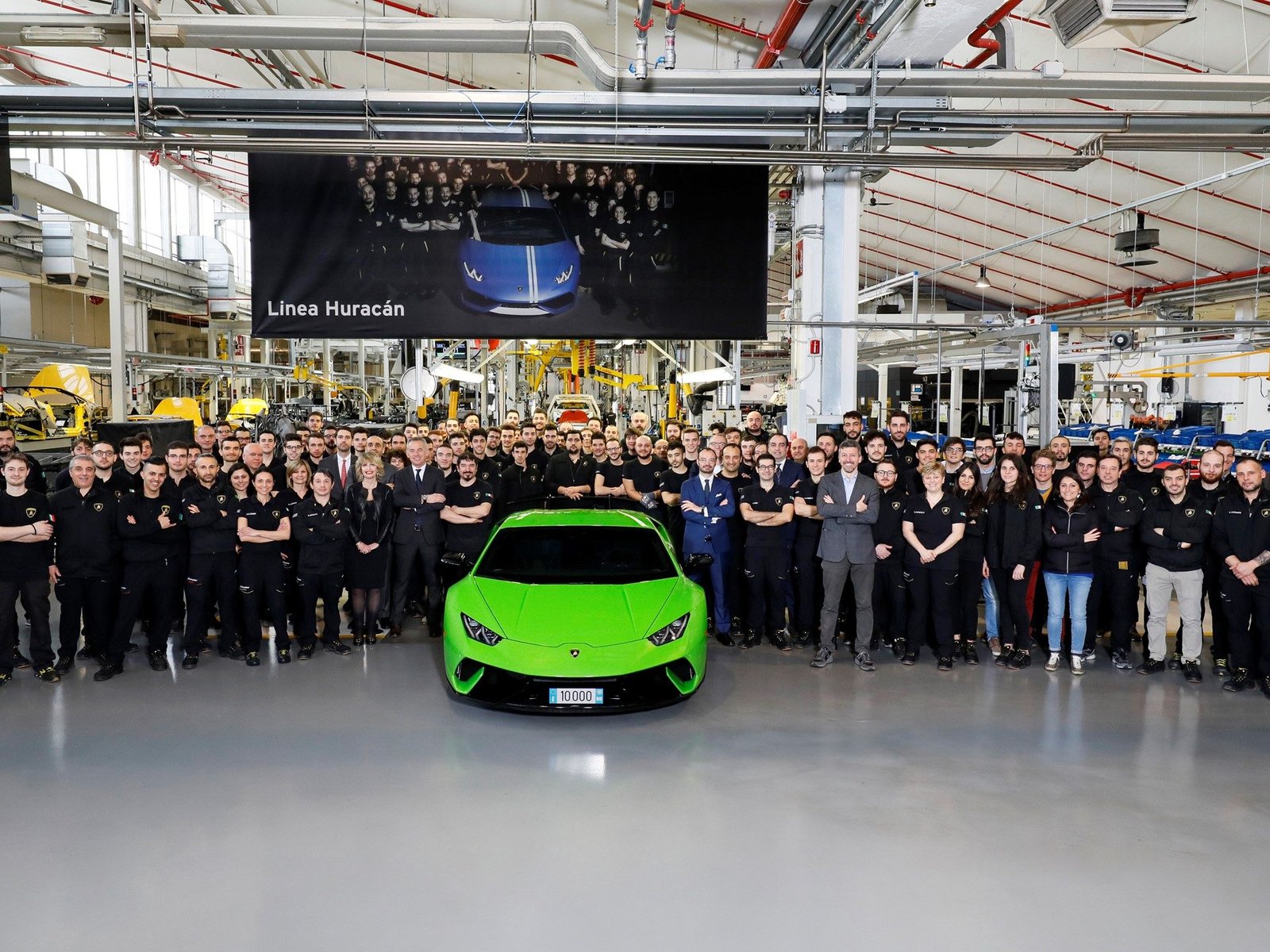 The 10,000th Lamborghini Huracán Performante in Verde Mantis on the Sant'Agata Bolognese assembly line, surrounded by factory workers and executives