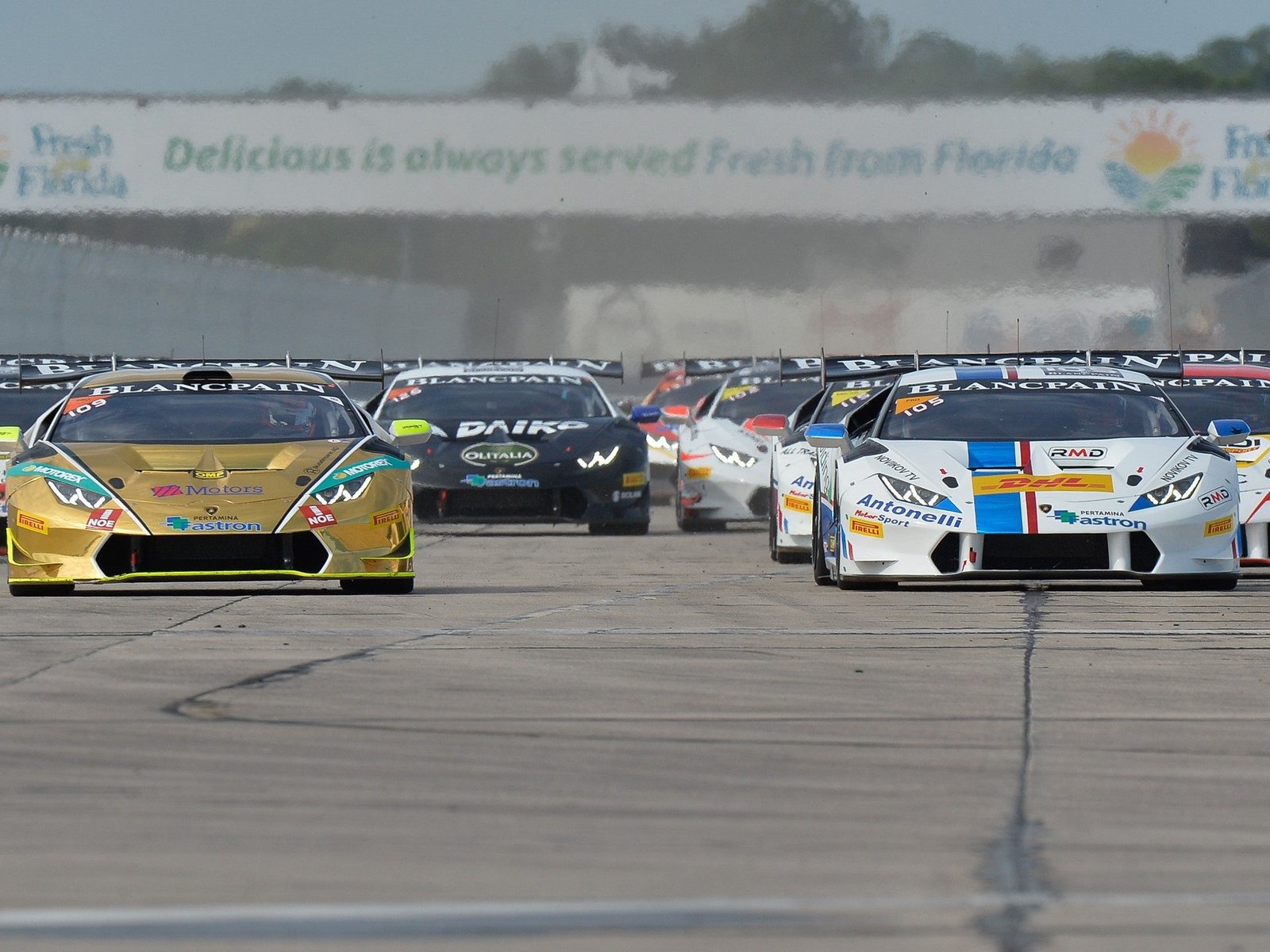 Lamborghini Huracán GT3 race cars competing wheel-to-wheel on a racetrack during the 2015 Super Trofeo season