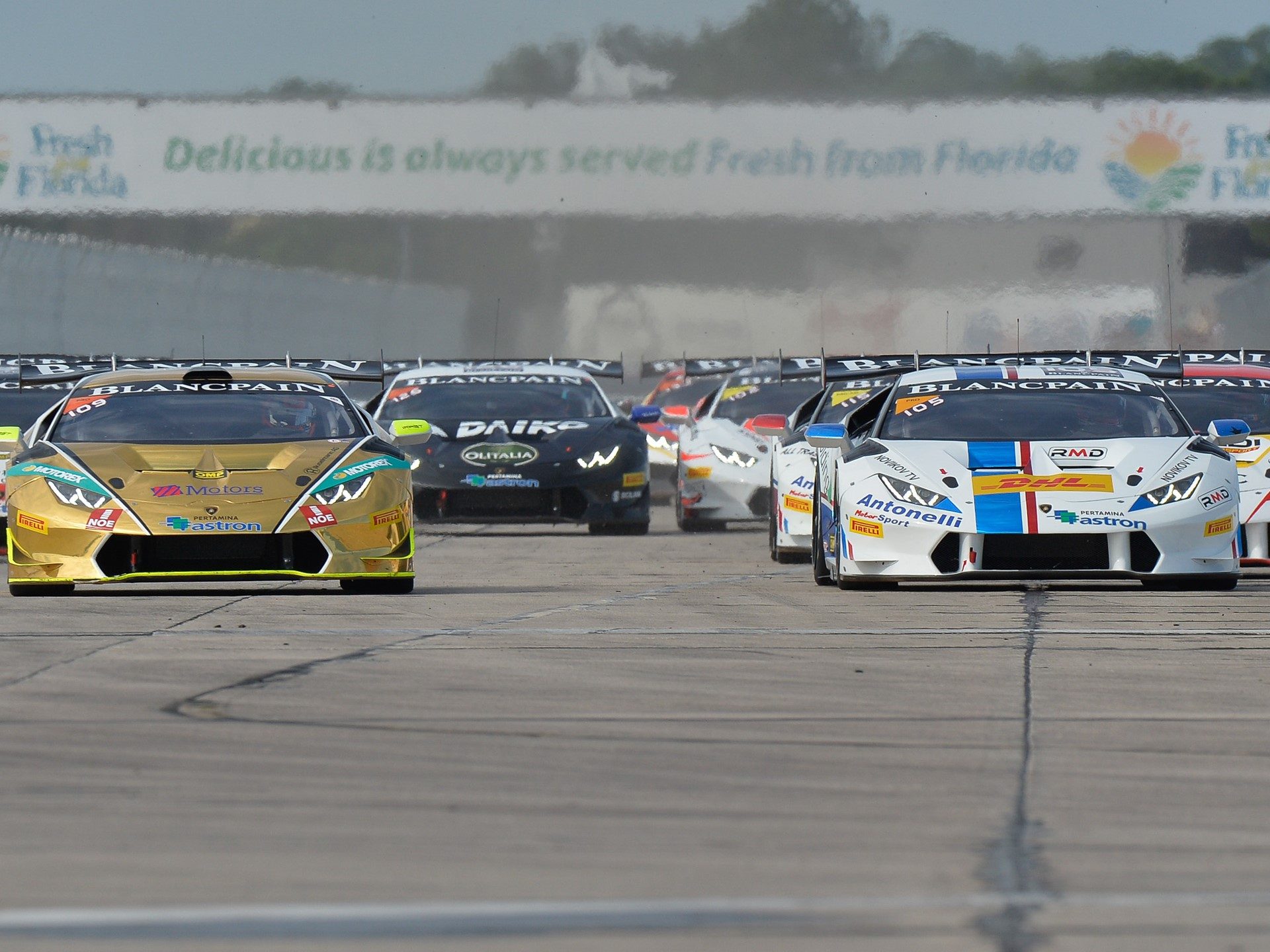 Lamborghini Huracán GT3 race cars competing wheel-to-wheel on a racetrack during the 2015 Super Trofeo season