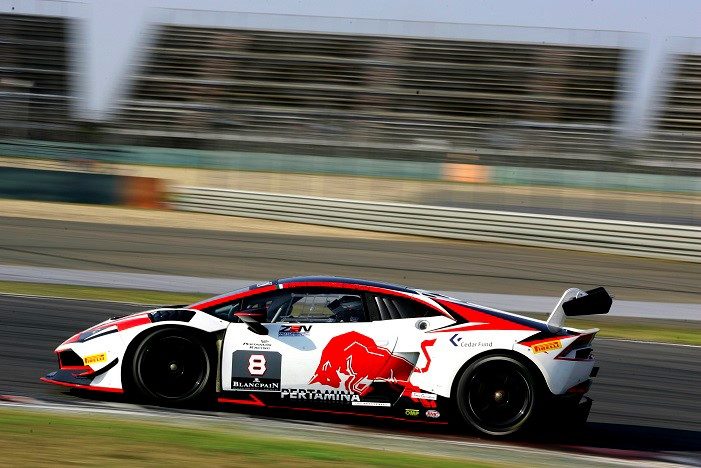 White Lamborghini Huracán Super Trofeo race car with Red Bull livery at speed on a racetrack