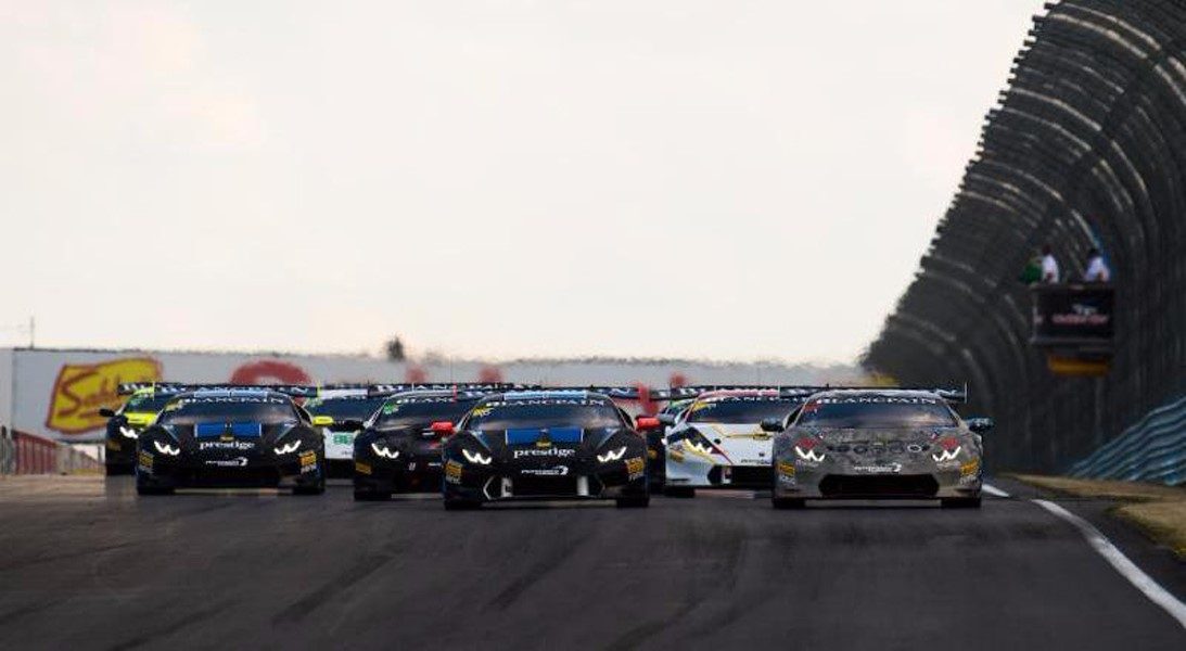 Row of lamborghini huracán super trofeo race cars on track showing aggressive aero kits, large rear wings, and racing liveries