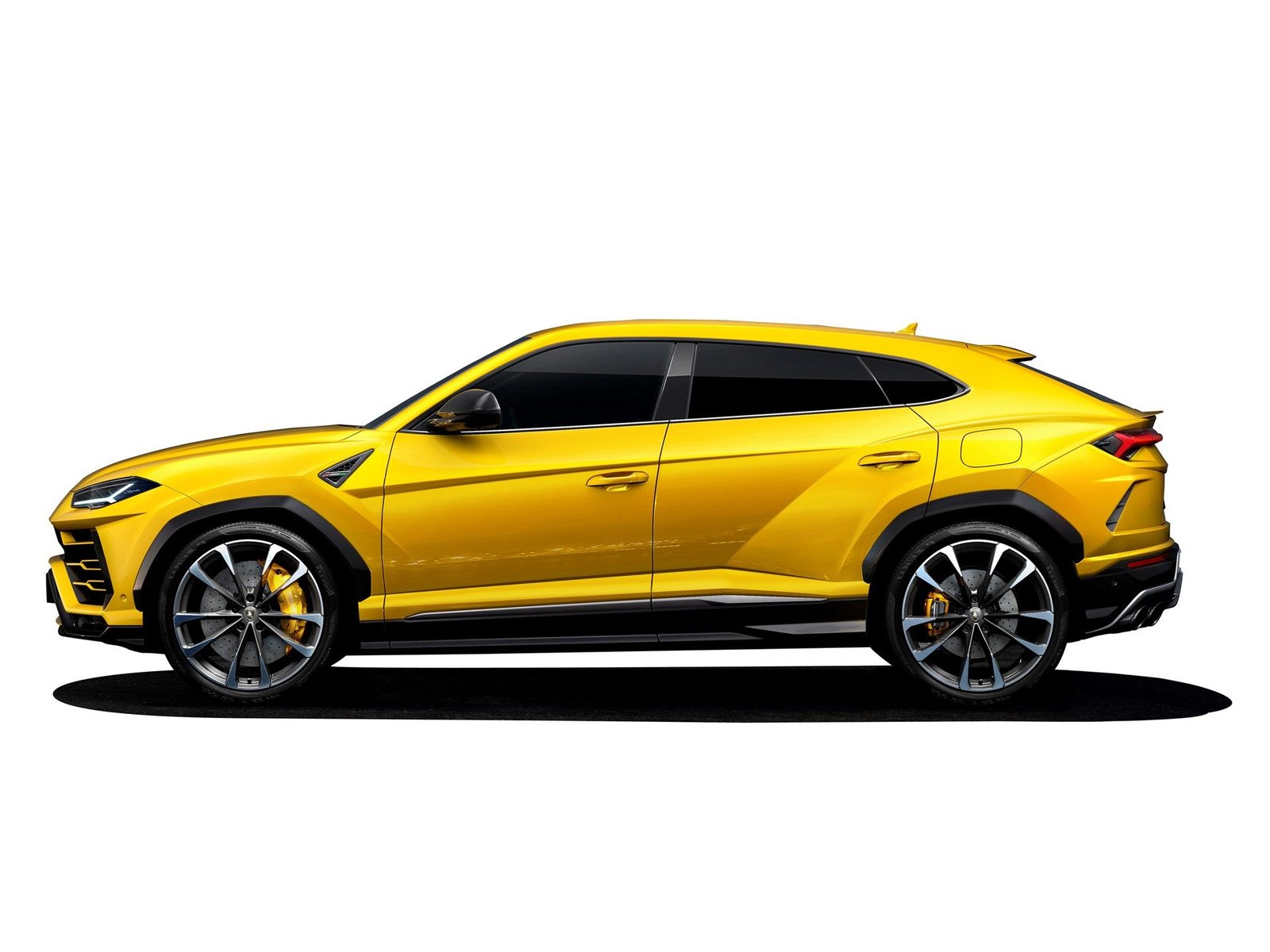 Yellow Lamborghini Urus in side profile showing aggressive lines, large wheels, and coupe-like roofline