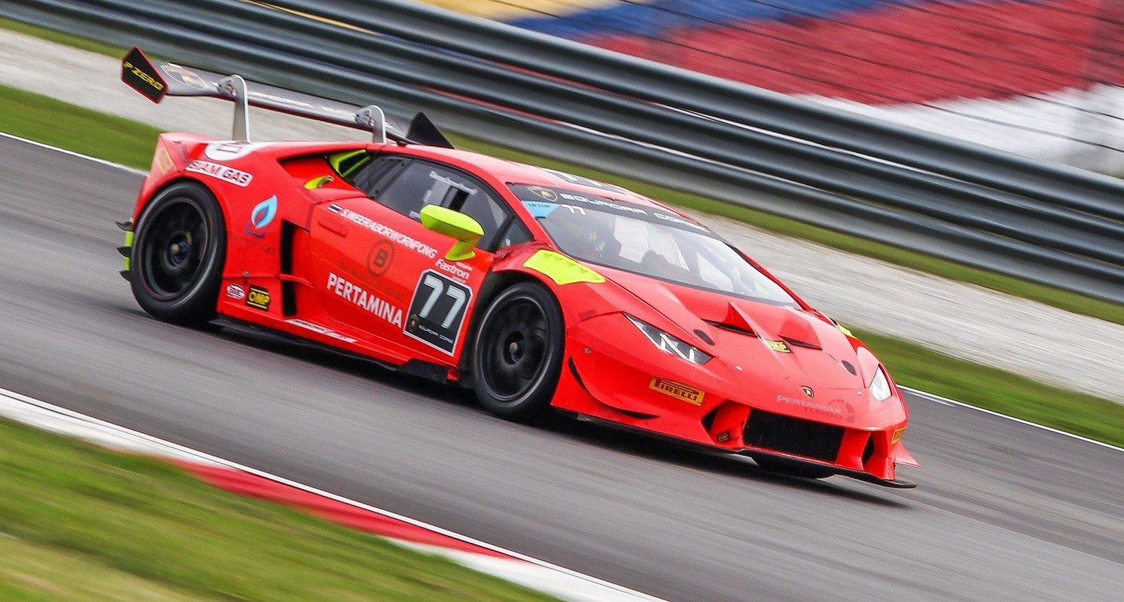Lamborghini Huracán race car with aerodynamic body kit and large rear wing at speed on circuit