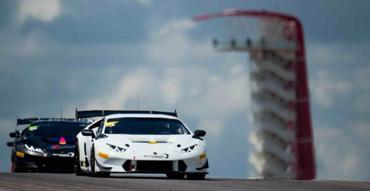 Two Lamborghini Huracán Super Trofeo race cars battling for position on track, with large rear wings and carbon fiber aero elements visible