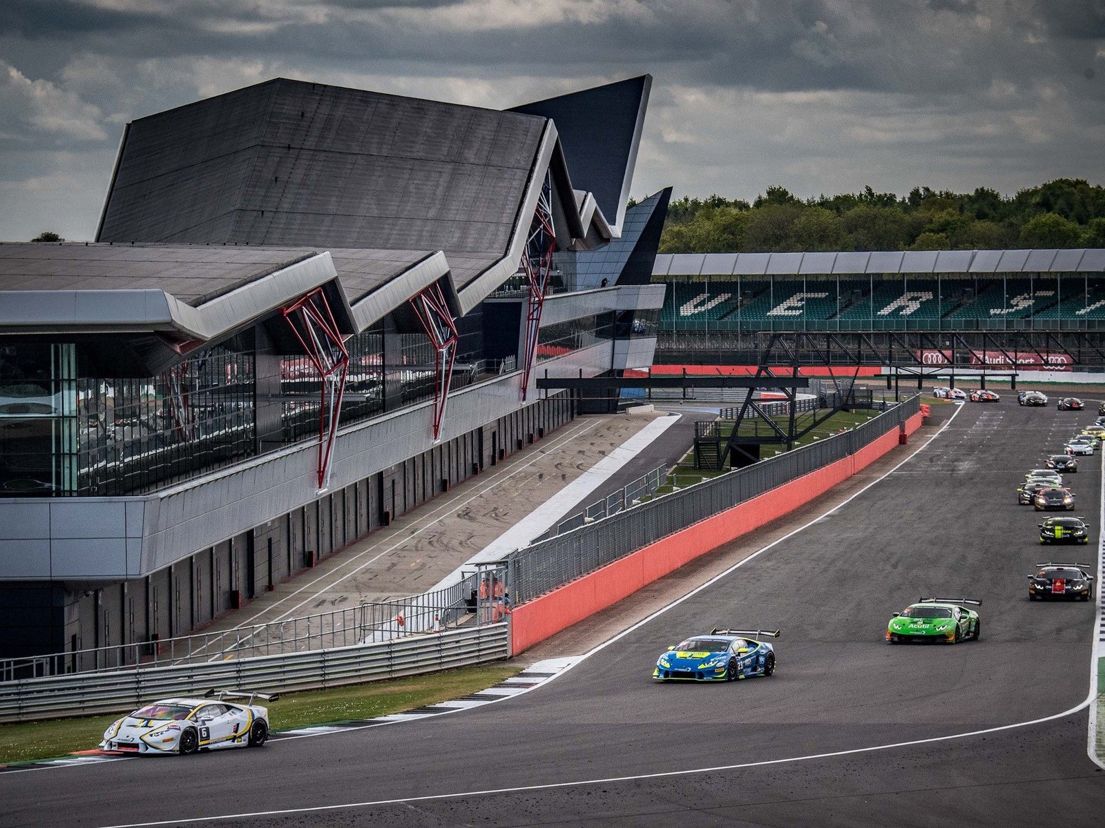 A blue Lamborghini Huracán Super Trofeo race car leads a pack through Silverstone during the 2017 Super Trofeo Europe round