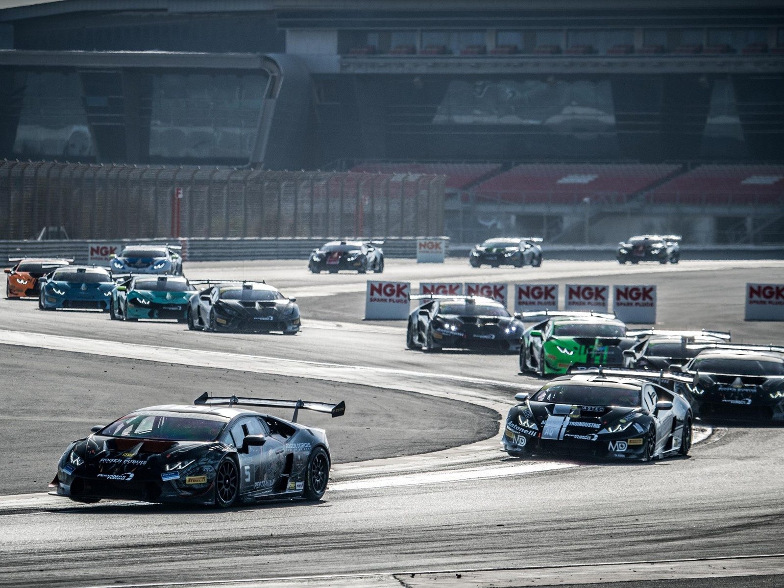 Lamborghini Huracán Super Trofeo race cars in close formation on circuit during 2018 Middle East series
