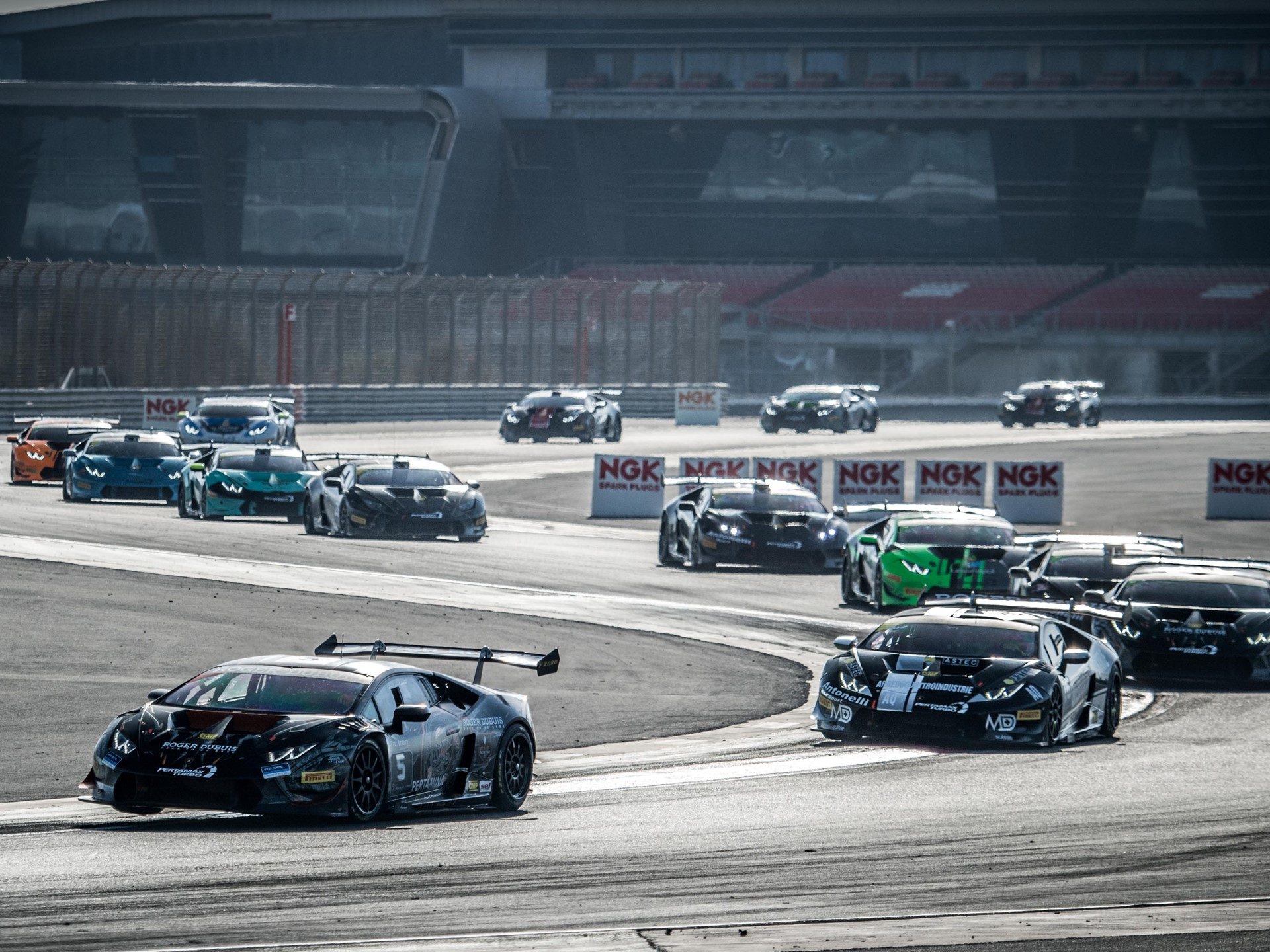 Lamborghini Huracán Super Trofeo race cars in close formation on circuit during 2018 Middle East series