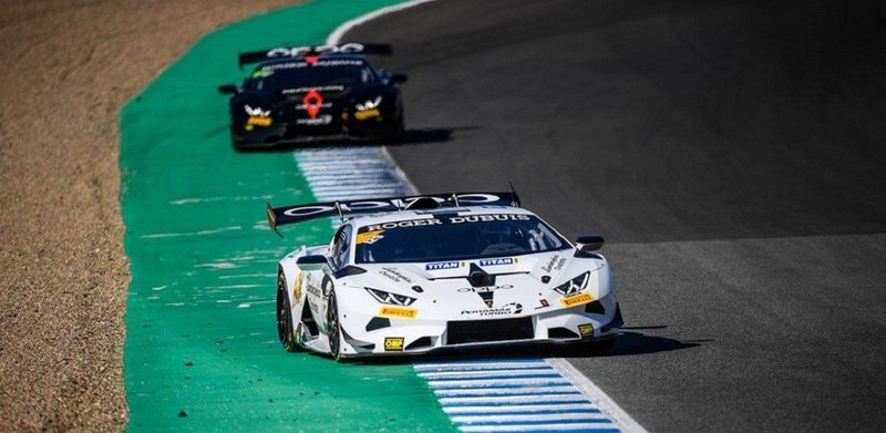 Two Lamborghini Huracán Super Trofeo EVO race cars battling through a corner at a racing circuit