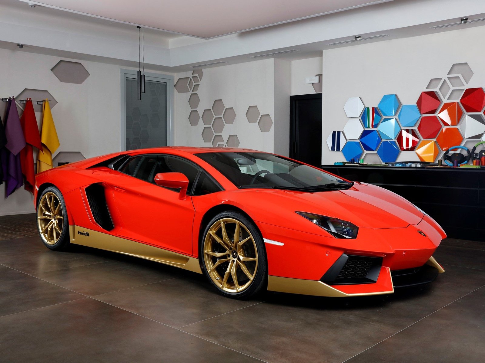 Red and gold two-tone Lamborghini Aventador Miura Homage with gold Dione wheels in a studio setting