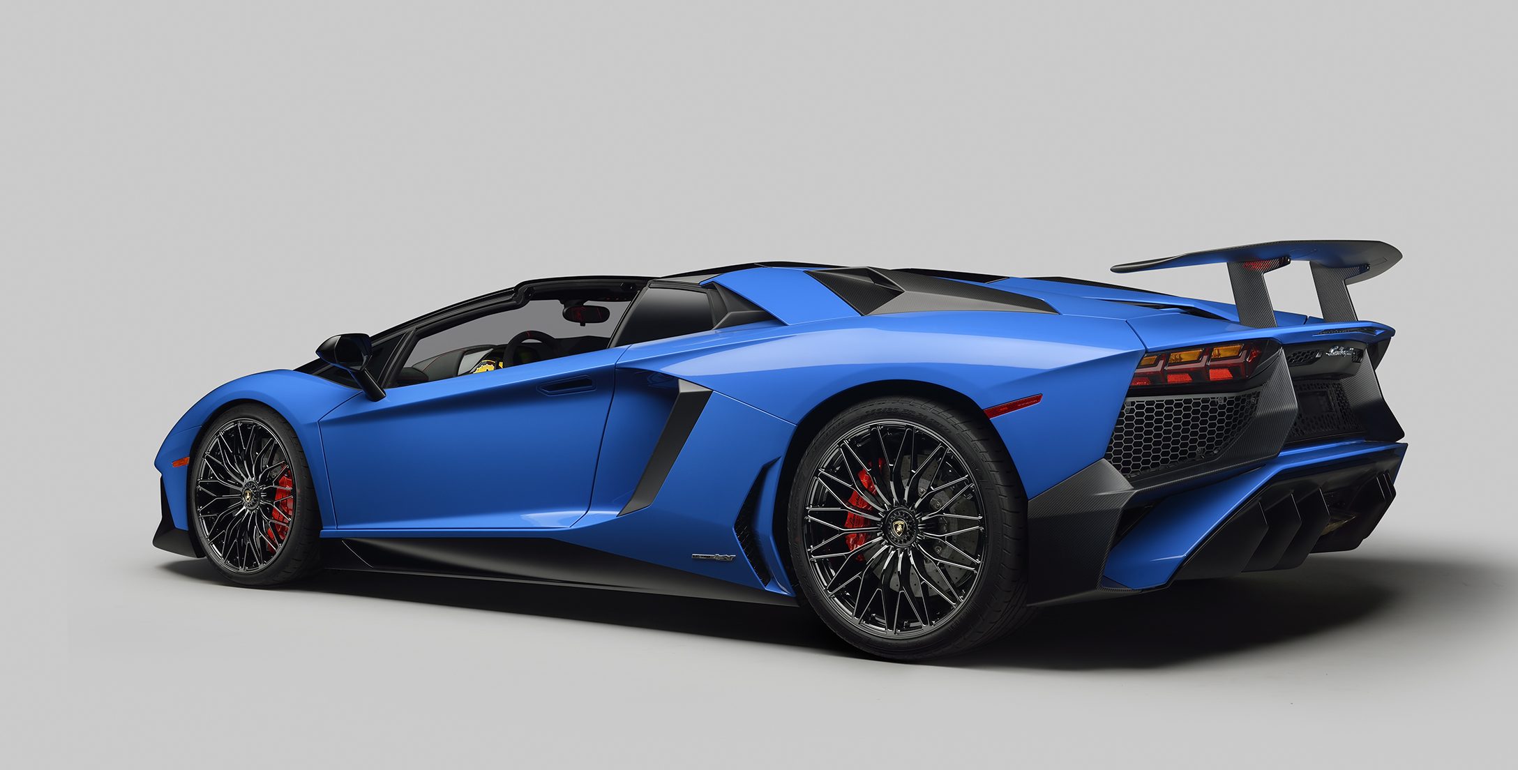 Blue Lamborghini Aventador LP 750-4 Superveloce Roadster rear three-quarter view showing large rear diffuser, quad exhaust tips, and massive rear wing