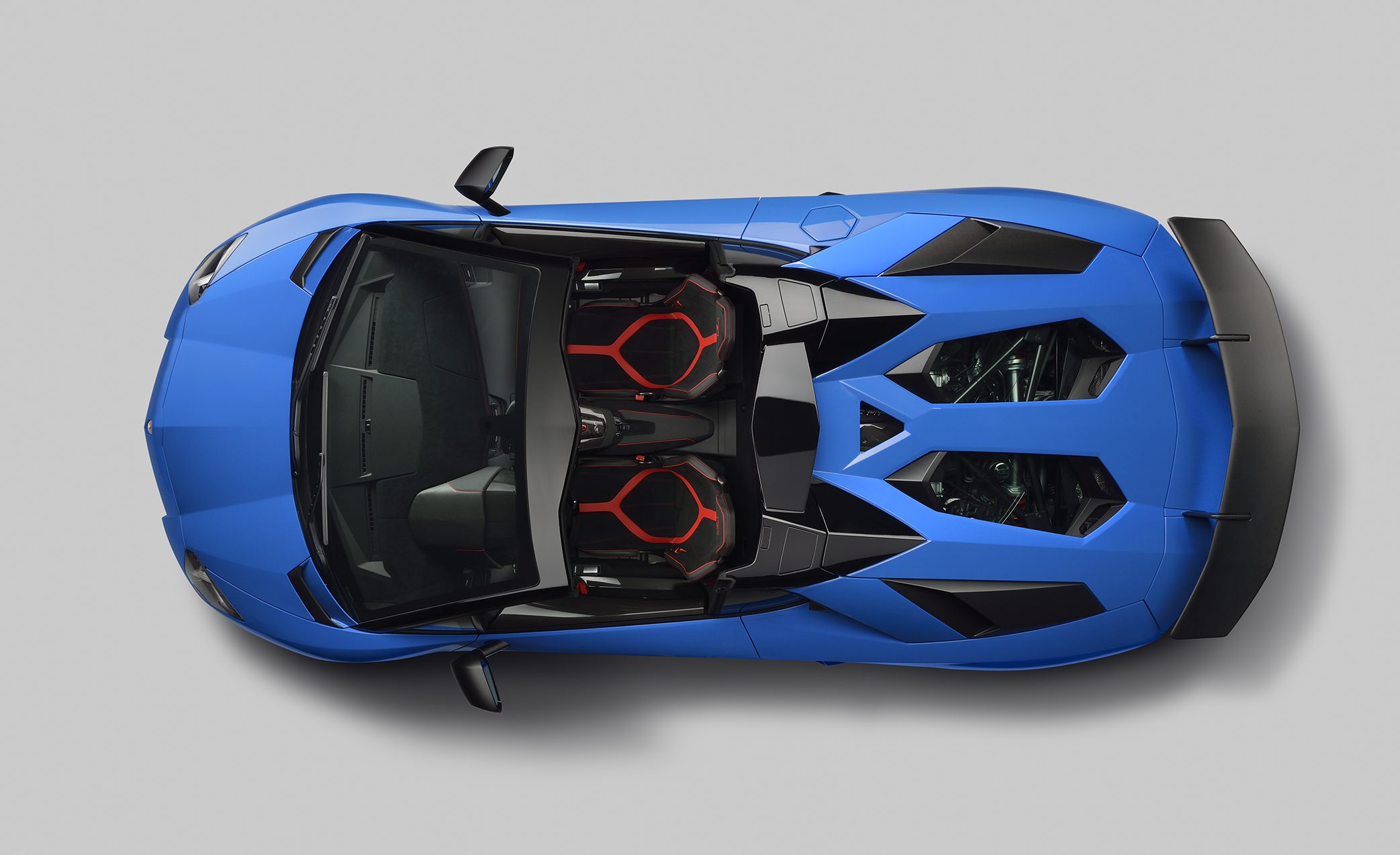 Overhead studio shot of blue Lamborghini Aventador LP 750-4 Superveloce Roadster showing aggressive design, hexagonal motifs, and open-top configuration