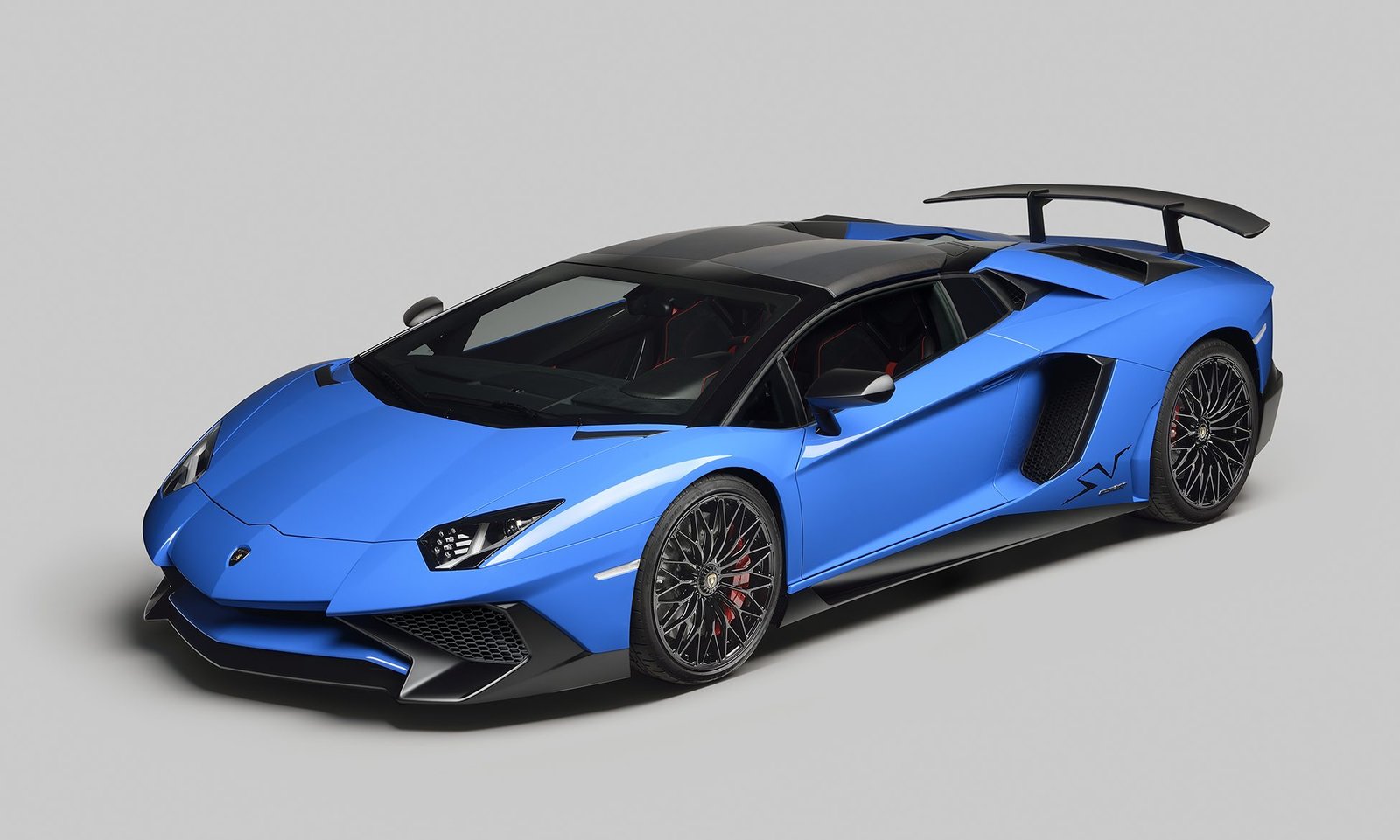 Blue Lamborghini Aventador LP 750-4 Superveloce Roadster front three-quarter view in studio setting showing aggressive bodywork and large rear wing