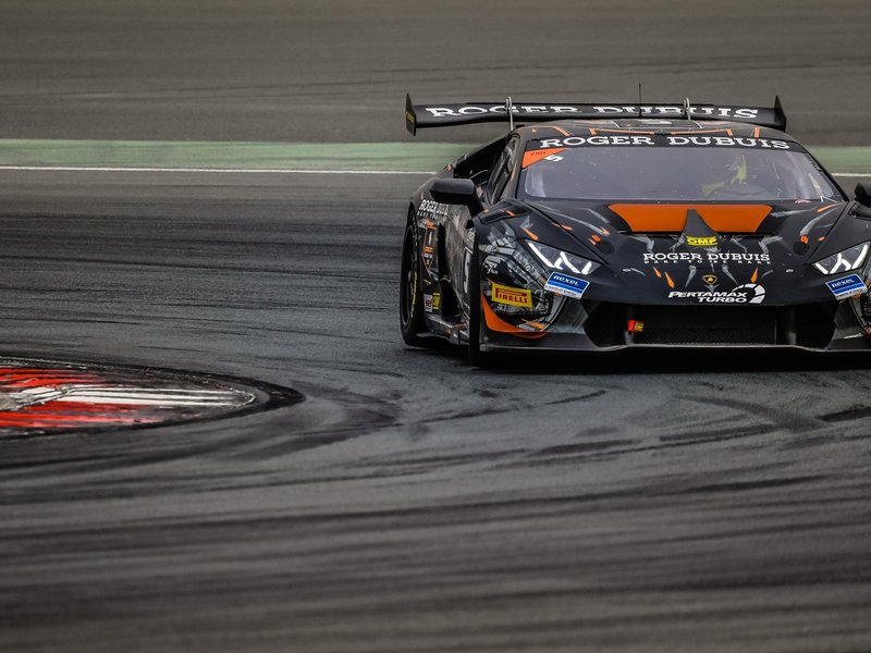 Lamborghini Huracán Super Trofeo race car with aerodynamic body kit and large rear wing navigating a corner at speed