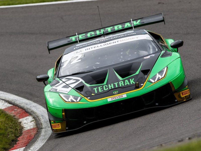 Green and black Lamborghini Huracán GT3 race car number 72 mid-corner on track with aggressive aero kit and large rear wing visible