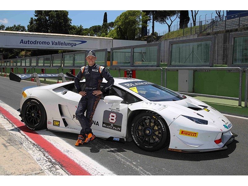 Casey Stoner standing beside a white Lamborghini Huracán Super Trofeo race car at the Autodromo Vallelunga circuit
