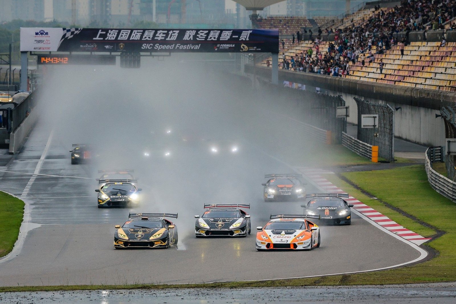 Lamborghini Huracán Super Trofeo race cars battle through spray on a wet Shanghai International Circuit during the 2017 Super Trofeo Asia round