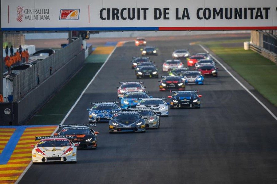 A pack of Lamborghini Huracán Super Trofeo race cars in various liveries racing down the straight at Circuit Ricardo Tormo in Valencia