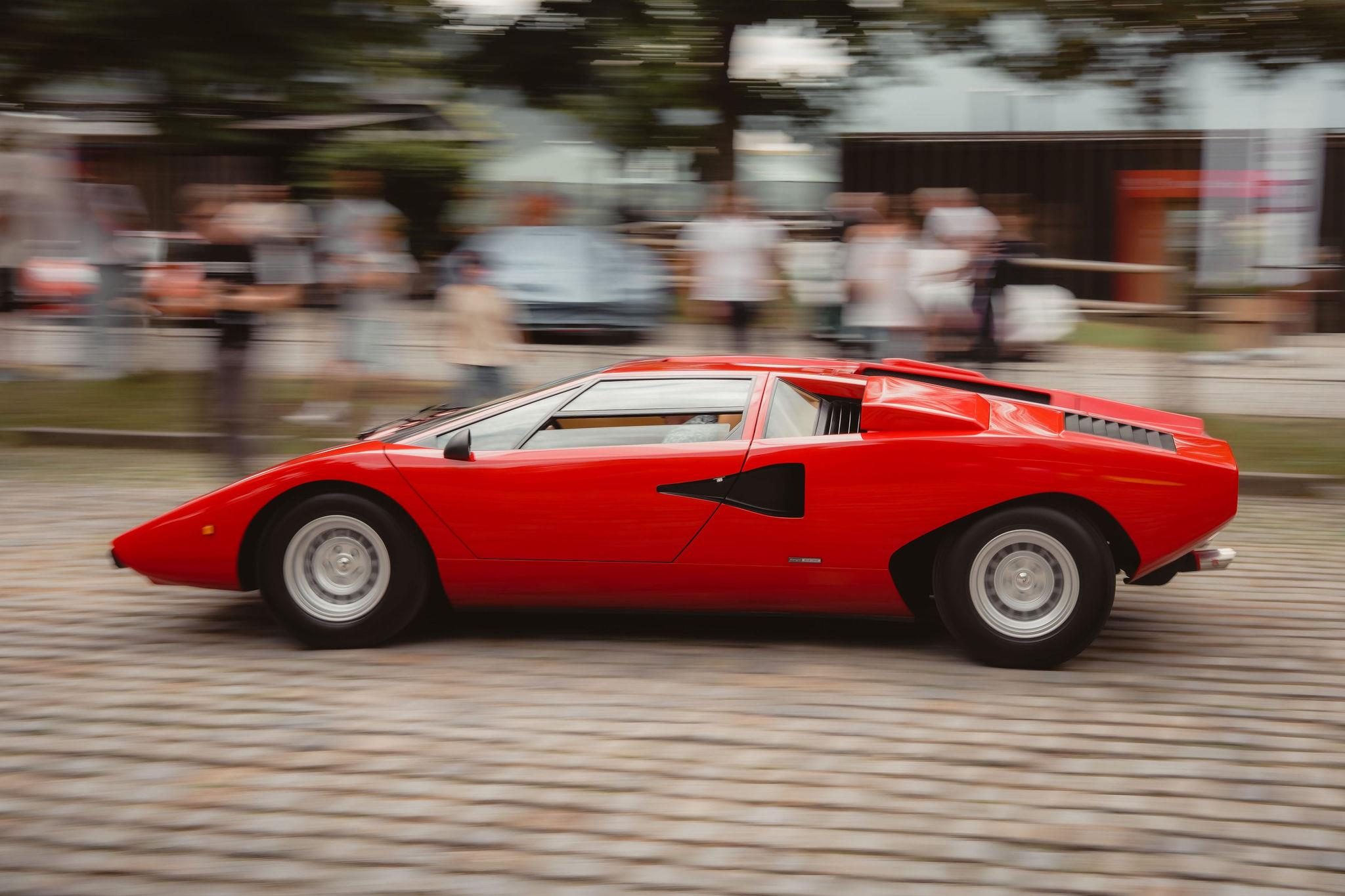 Fenomeno Roadster At Lake Tegernsee: Why Lamborghini Chose A Concours Lawn Over A Motor Show Stage 9 Red lamborghini countach lp400 in motion on a cobblestone street at the concours of elegance germany event
