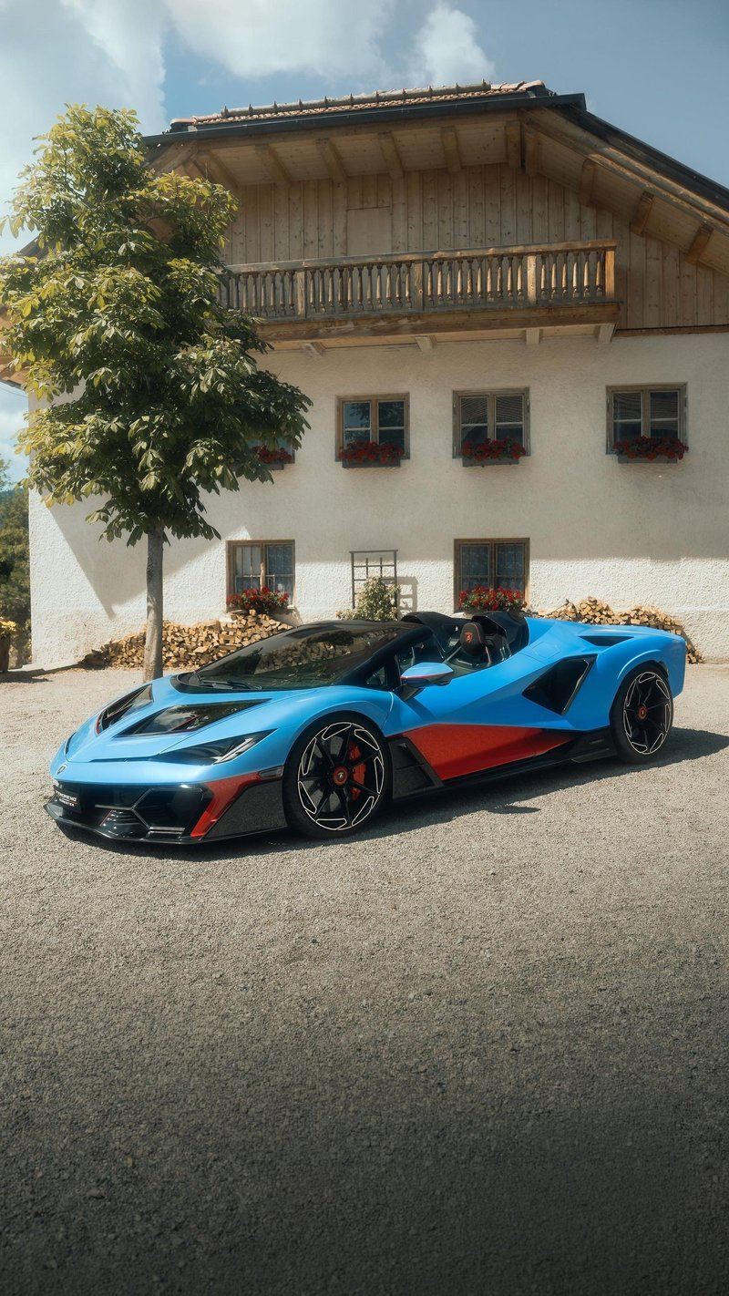 Blue and red Lamborghini Fenomeno Roadster parked on a gravel driveway in front of a traditional Bavarian house at Concours of Elegance Germany 2026