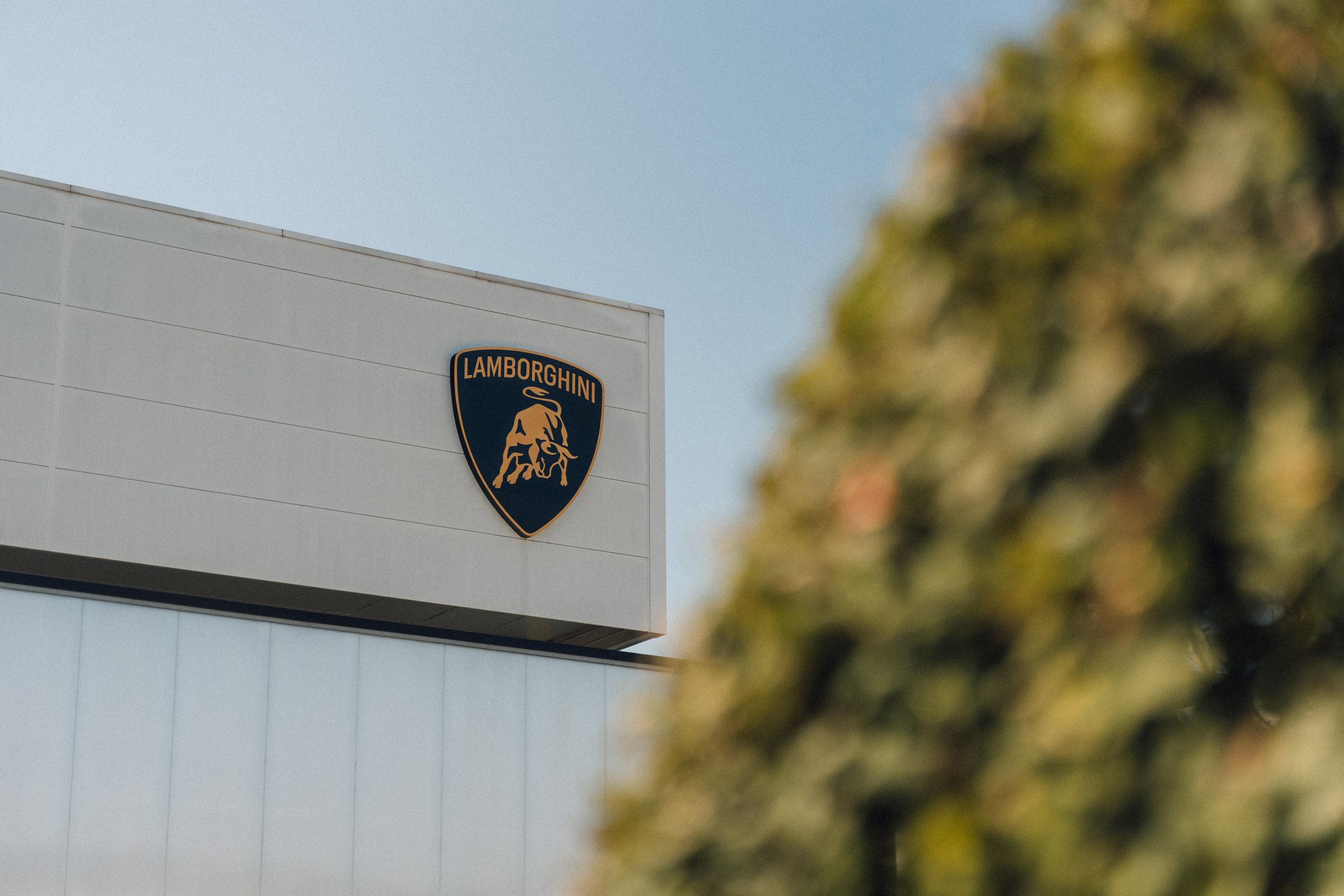 Lamborghini'S New Marketing Director Comes From Ducati, And That Choice Tells You Everything 7 Close-up of the lamborghini shield logo on the side of the factory building in sant'agata bolognese