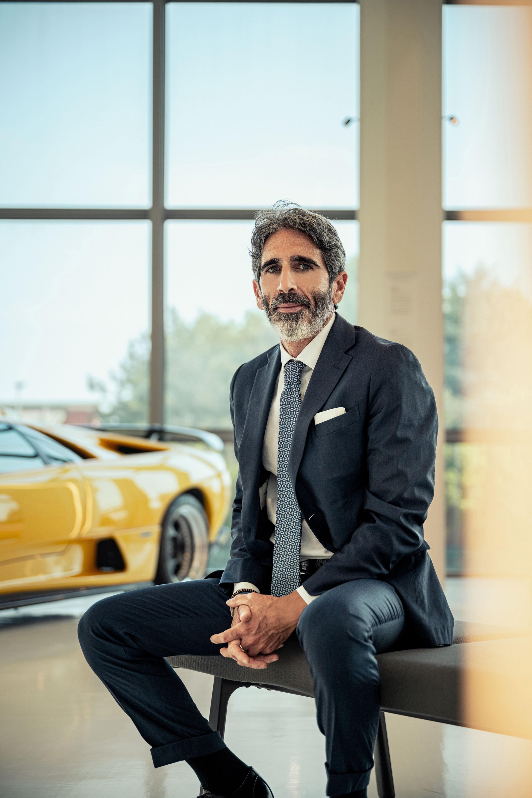 Lamborghini'S New Marketing Director Comes From Ducati, And That Choice Tells You Everything 3 Francesco milicia seated on a bench with a yellow lamborghini diablo visible in the background