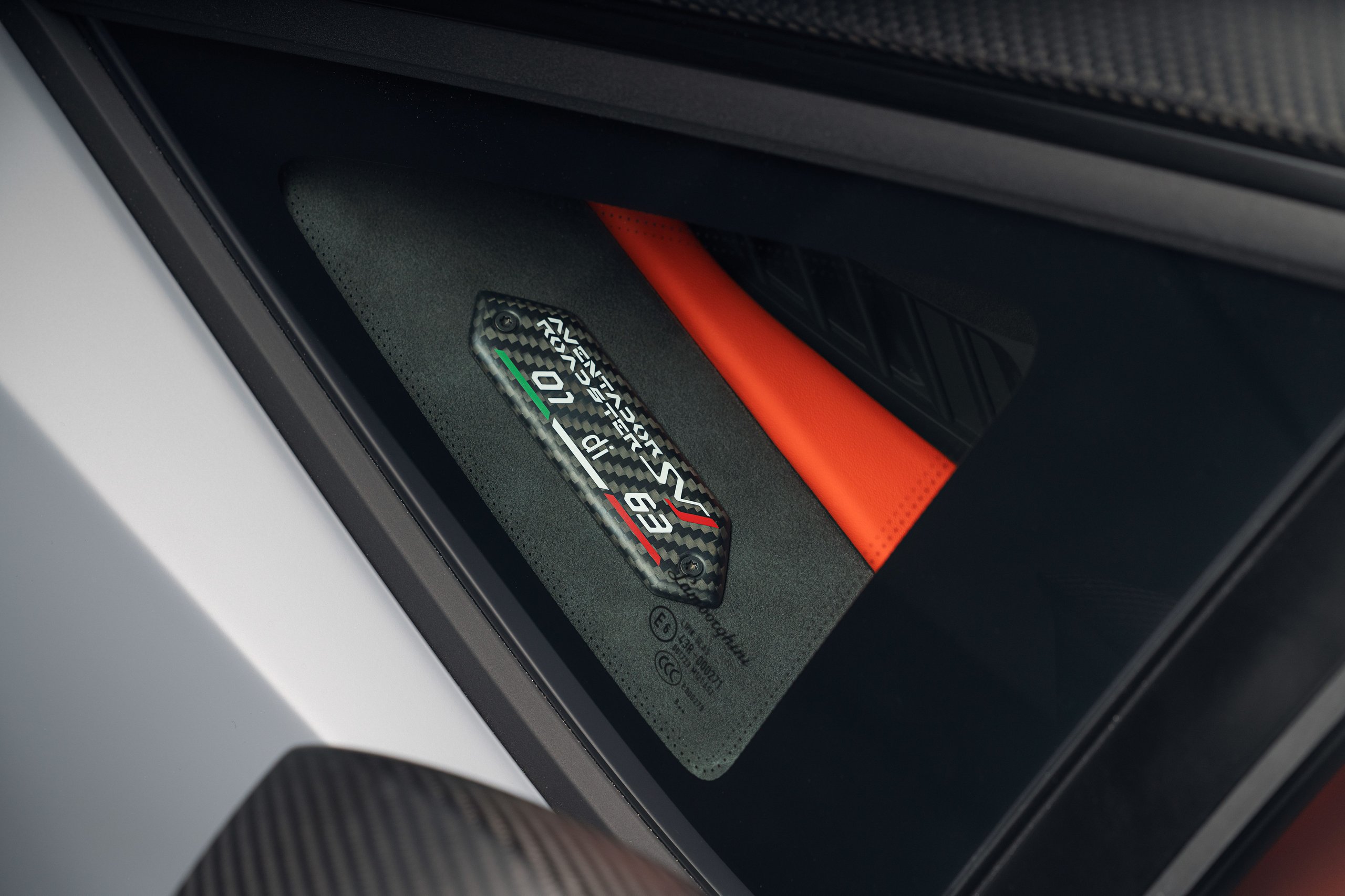 Close-up of the '01 of 63' carbon fiber plaque on the aventador svj 63 roadster with svj logo and italian flag detail