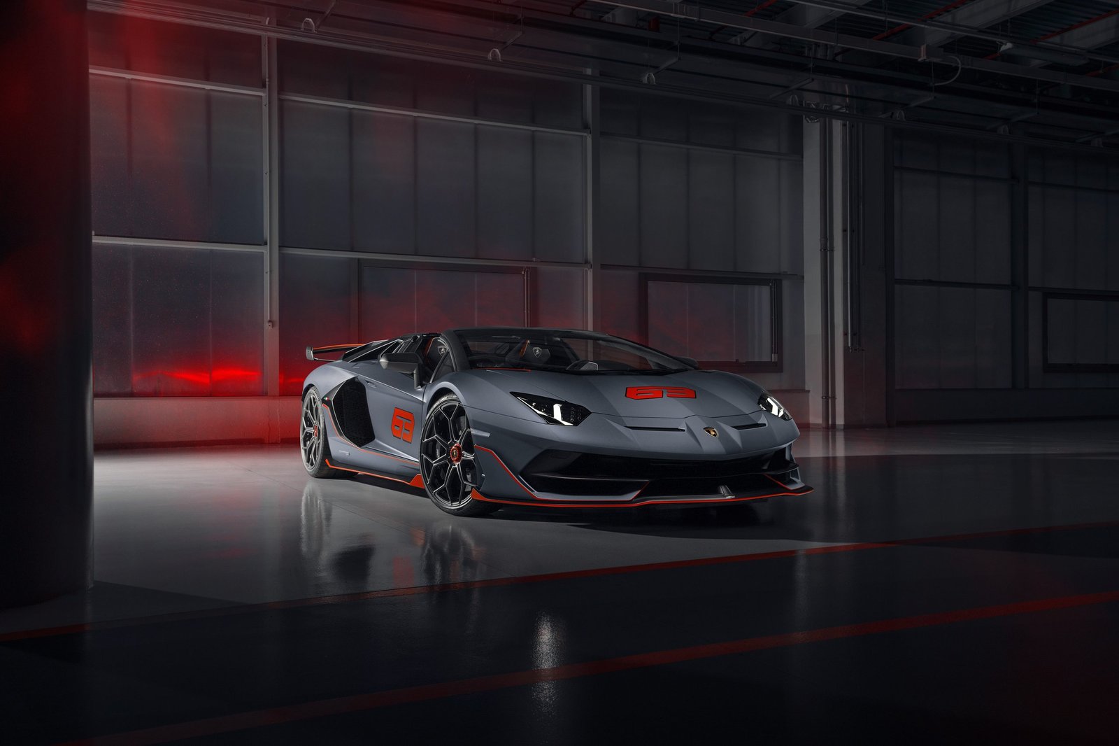 Front three-quarter view of the Lamborghini Aventador SVJ 63 Roadster in matt grey Grigio Acheso with orange Arancio Dac accents