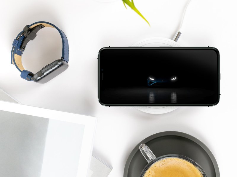 Smartphone displaying the Lamborghini Huracán EVO RWD Spyder headlights on a styled desk with Apple Watch and coffee
