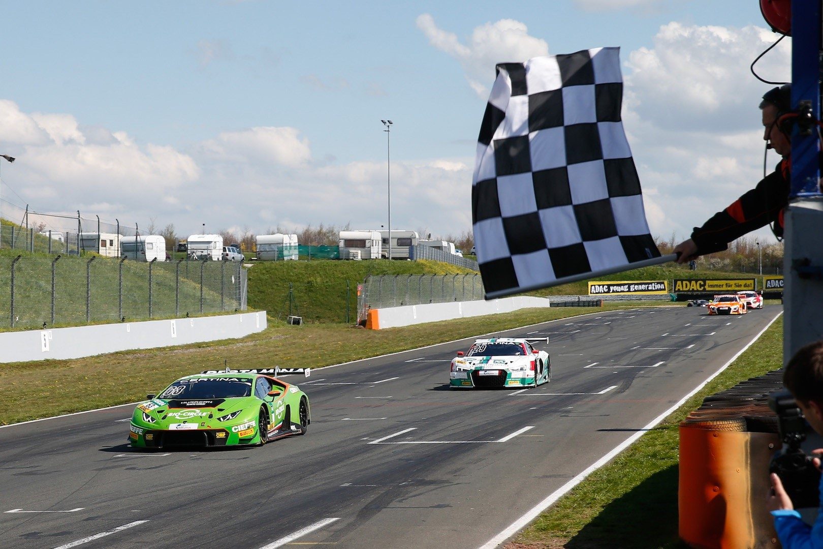 Green lamborghini huracán gt3 takes the checkered flag at the 2016 adac gt masters at oschersleben