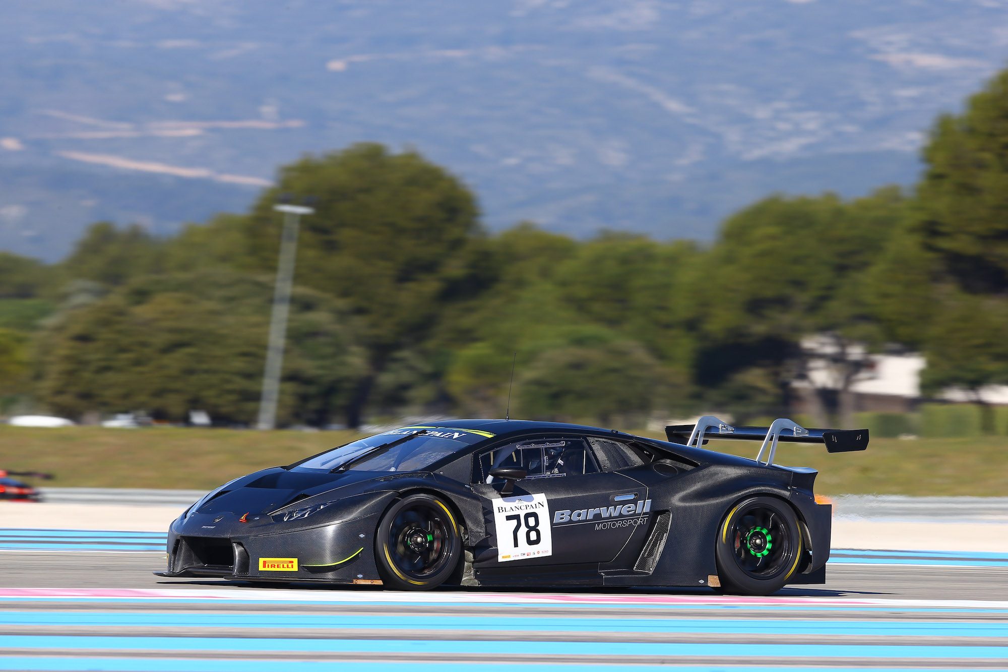 Dark-bodied Lamborghini Huracán GT3 with green accents racing on track during the 2016 Blancpain GT Series test days