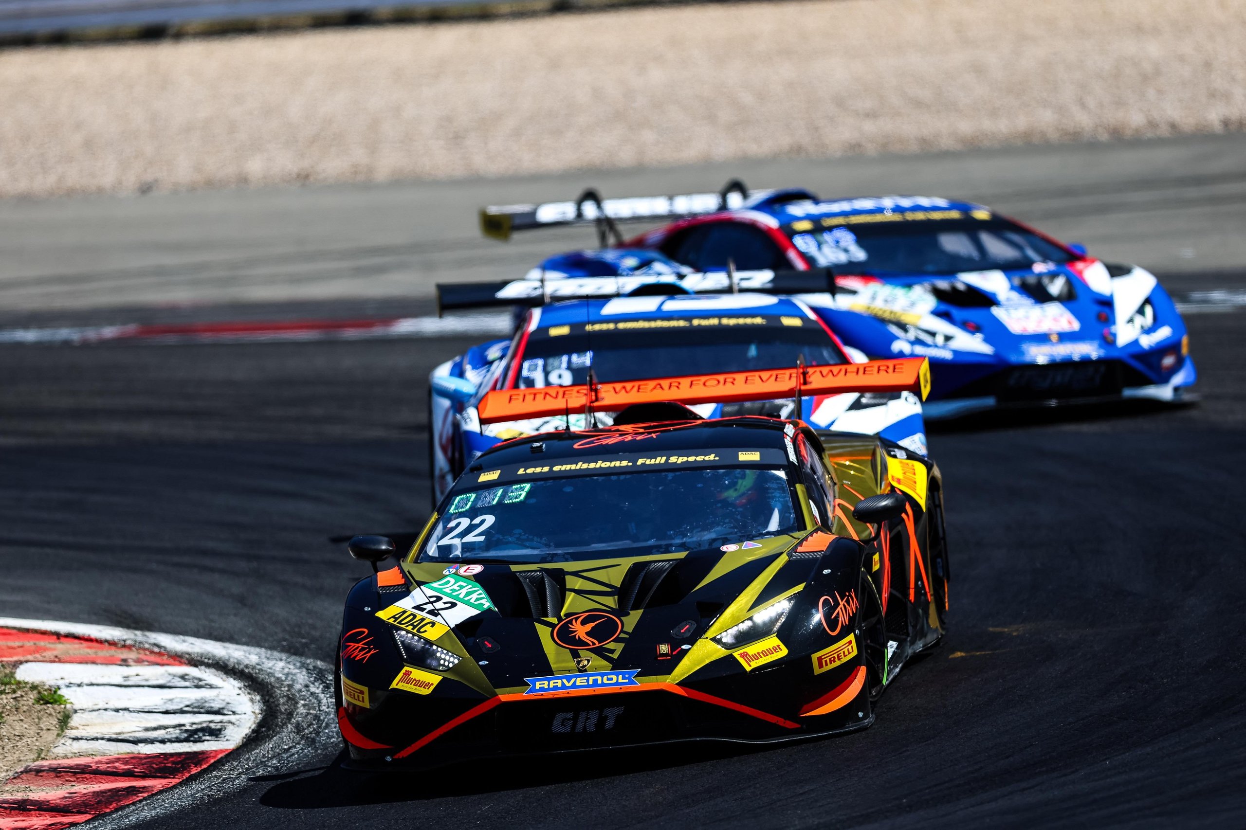 Three lamborghini huracán gt3 evo2 race cars battling through a corner at the nürburgring adac gt masters