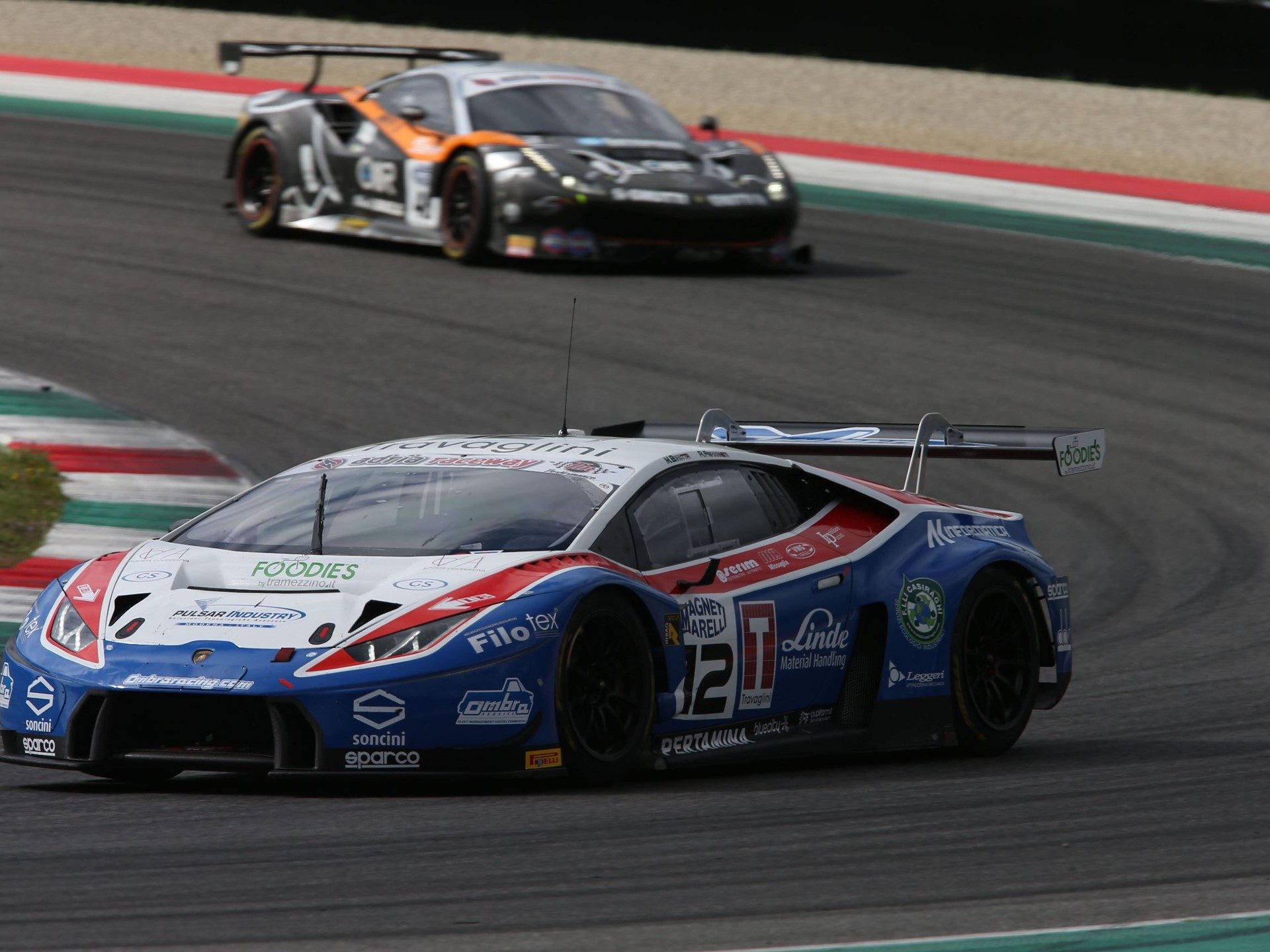 Lamborghini Huracán GT3 in blue, white, and red Ombra Racing livery navigating a turn during the Italian GT Championship