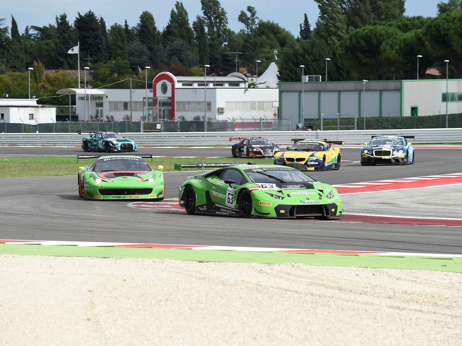 Green Lamborghini Huracan GT3 leading a pack of GT3 race cars on the Misano circuit during the 2015 Blancpain Sprint Series