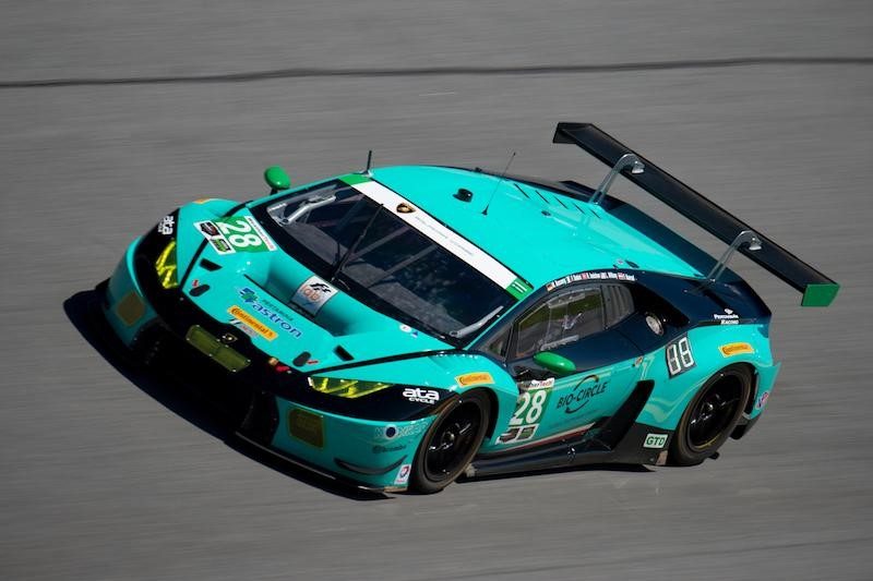 Lamborghini huracán gt3 race car in teal and black livery on track, showing the large rear wing and aggressive aerodynamic body kit