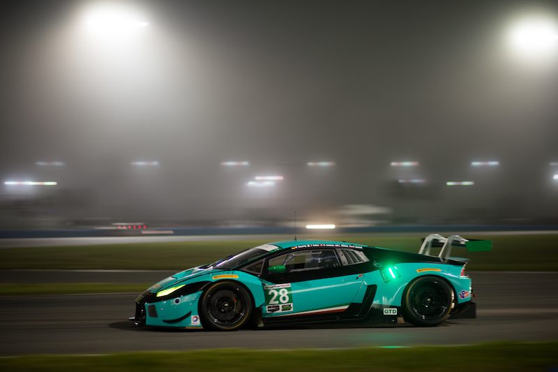 Blue Lamborghini Huracán GT3 number 28 racing at night on the Daytona track with misty background lighting
