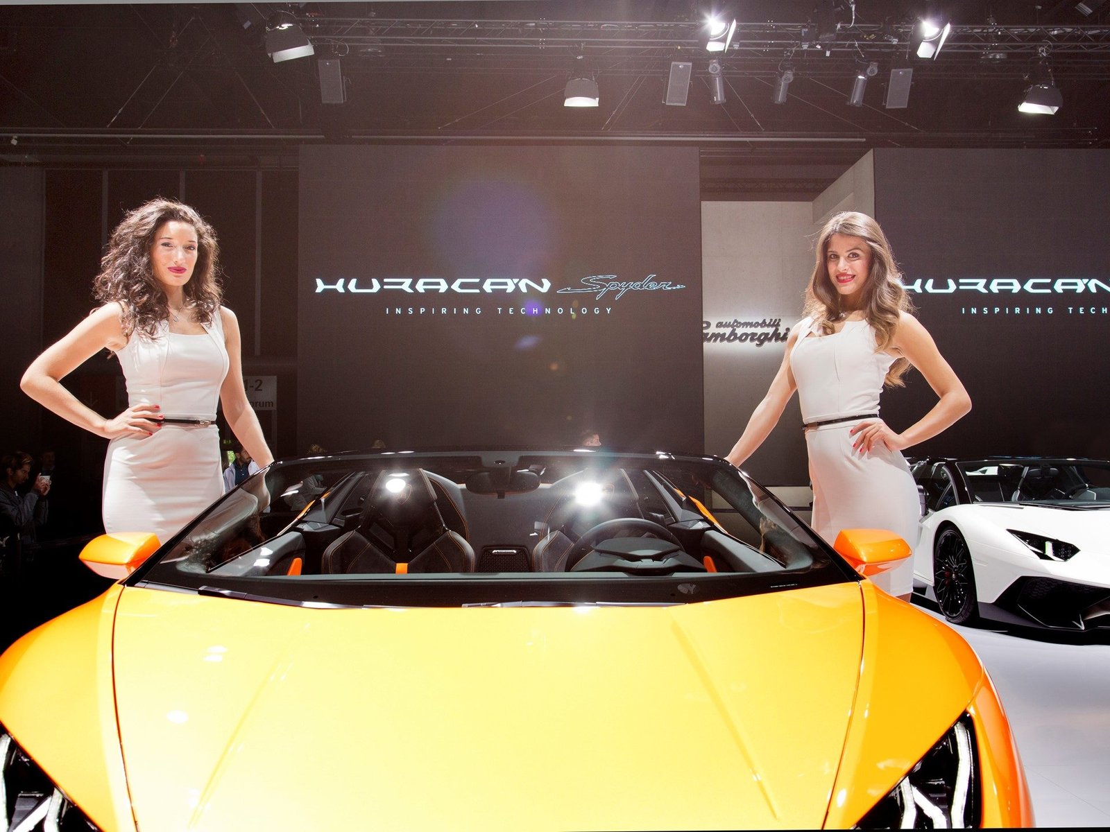 Orange Lamborghini Huracán LP 610-4 Spyder on display at the Frankfurt Motor Show with a white Aventador in the background