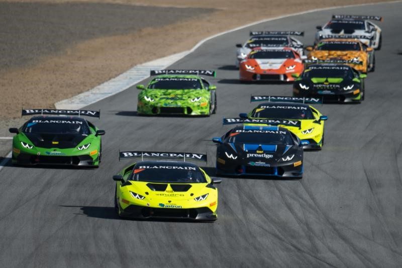 A pack of Lamborghini Huracán LP 620-2 Super Trofeo race cars in green, yellow, black, orange, and white liveries battling for position on track during the 2015 Super Trofeo North America season.