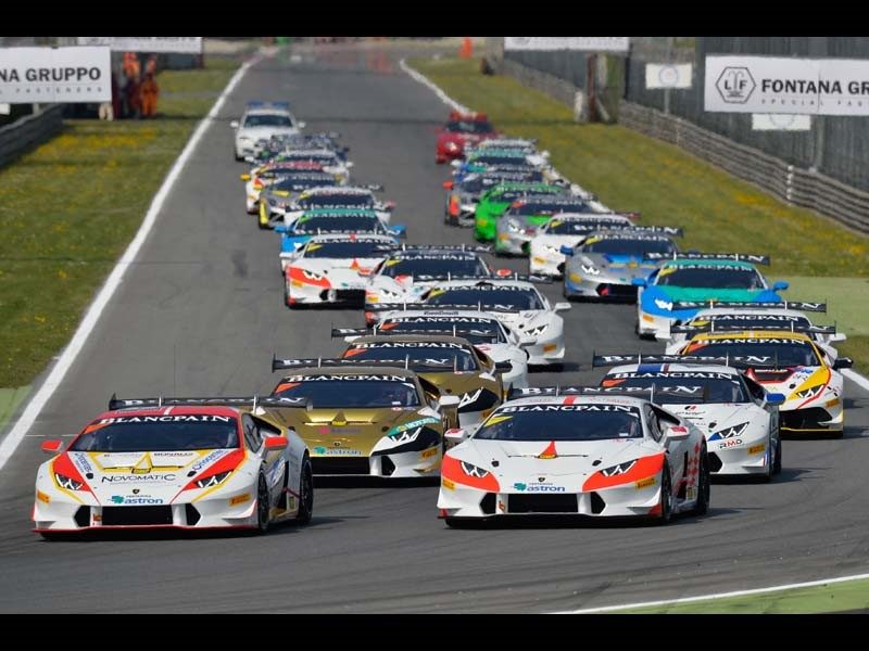Full grid of Lamborghini Huracán Super Trofeo race cars on track at Monza with aggressive aero kits, large rear wings, and racing liveries