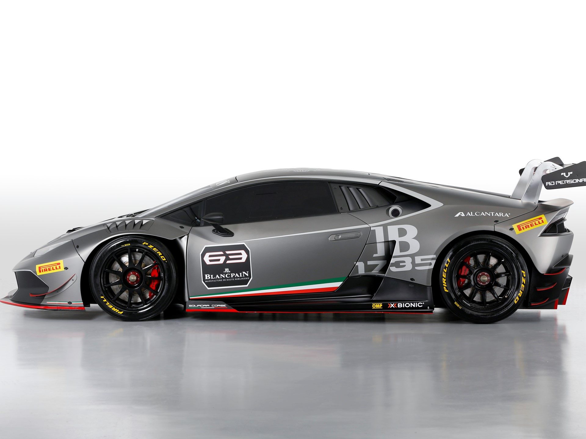 Grey Lamborghini Huracán LP 620-2 Super Trofeo race car in studio with racing livery, large rear wing, and Pirelli racing tires