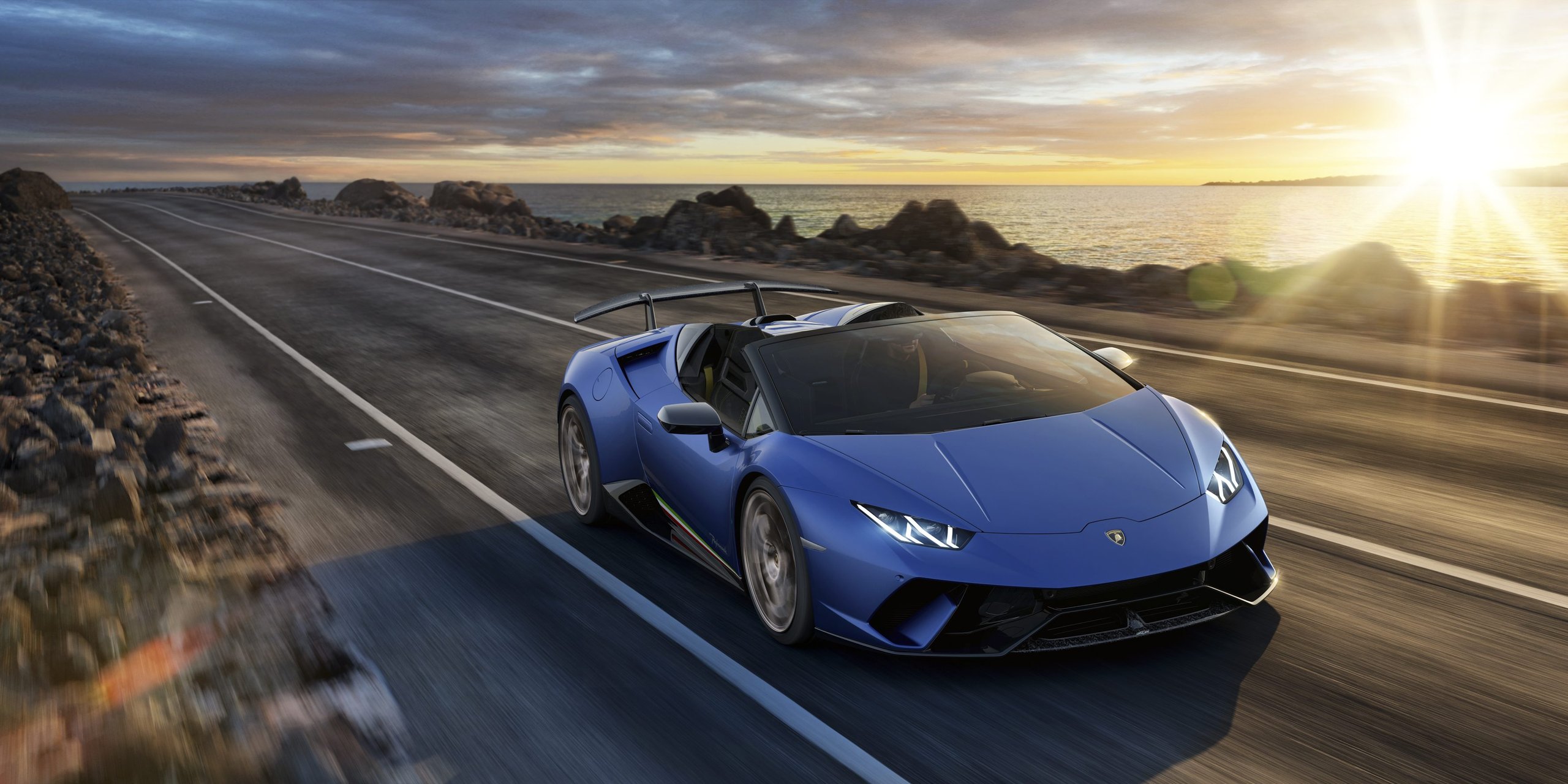 How Lamborghini Kept The Performante Spyder From Being A Compromise 7 Blue lamborghini huracán performante spyder driving on a coastal road at sunset with motion blur