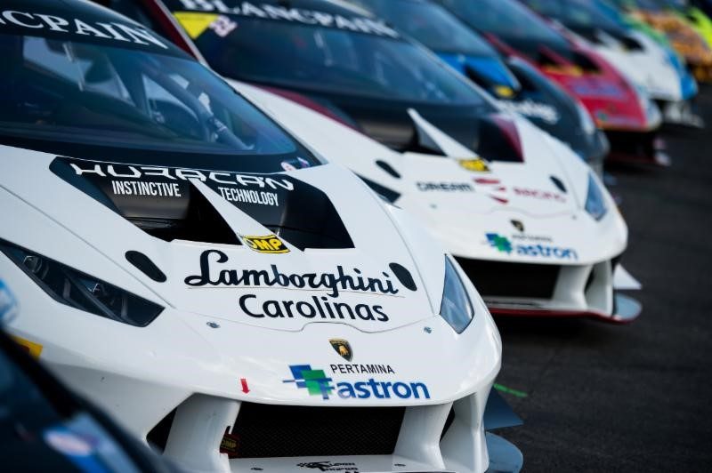 Lamborghini Huracán Super Trofeo race cars lined up on track with aerodynamic body kits, large air intakes, and sponsor liveries visible