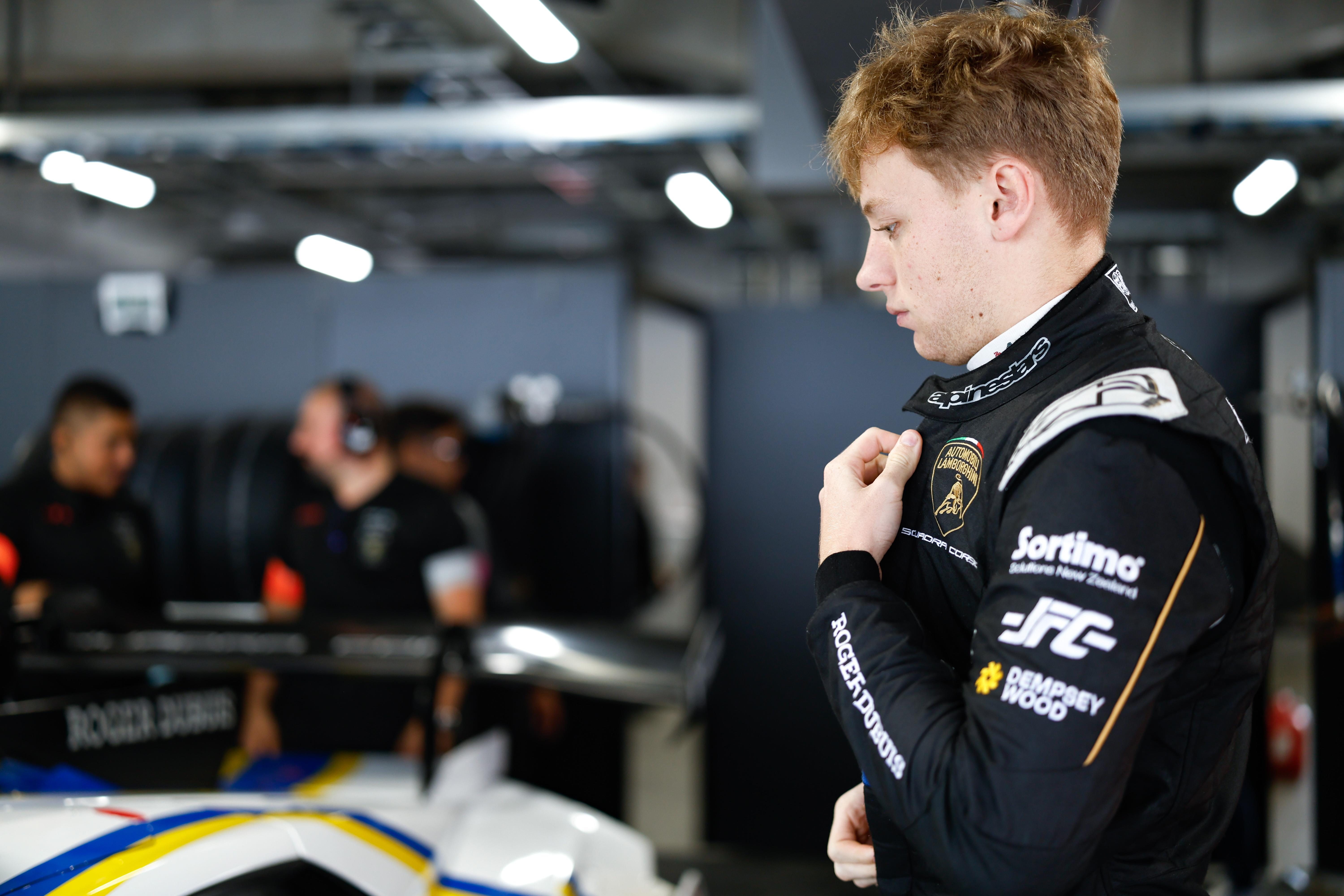 Thirty Drivers, One Goal: Inside Lamborghini'S 2026 Young Driver Programs And The Formula Medicine Gambit 7 A young racing driver in a lamborghini squadra corse suit adjusting his collar in a garage setting