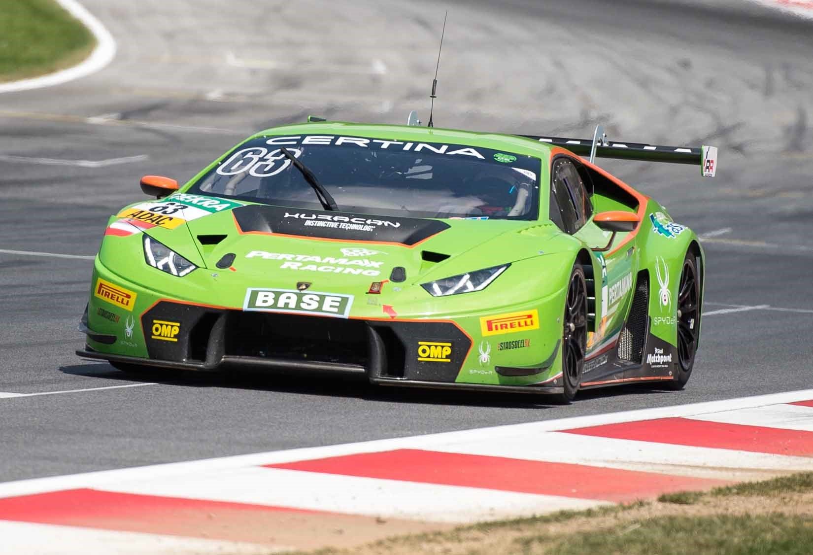 Green Lamborghini Huracán GT3 with orange accents racing at the Red Bull Ring during the 2015 ADAC GT Masters