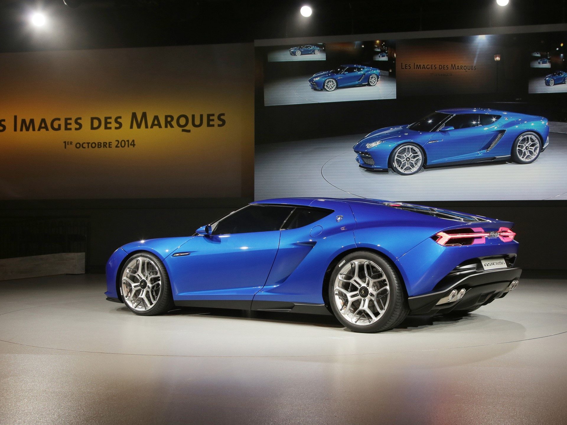 Blue Lamborghini Asterion LPI 910-4 concept displayed at the 2014 Paris Motor Show with futuristic lines and prominent rear diffuser