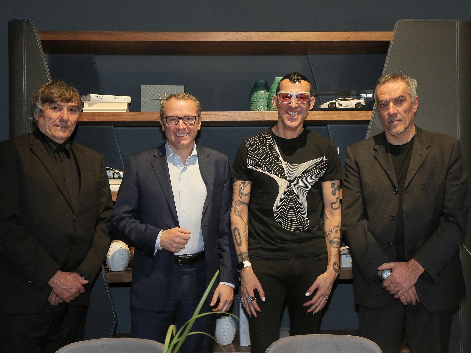 Karim Rashid in pink sunglasses alongside Lamborghini and Riva 1920 executives at the Salone del Mobile furniture launch