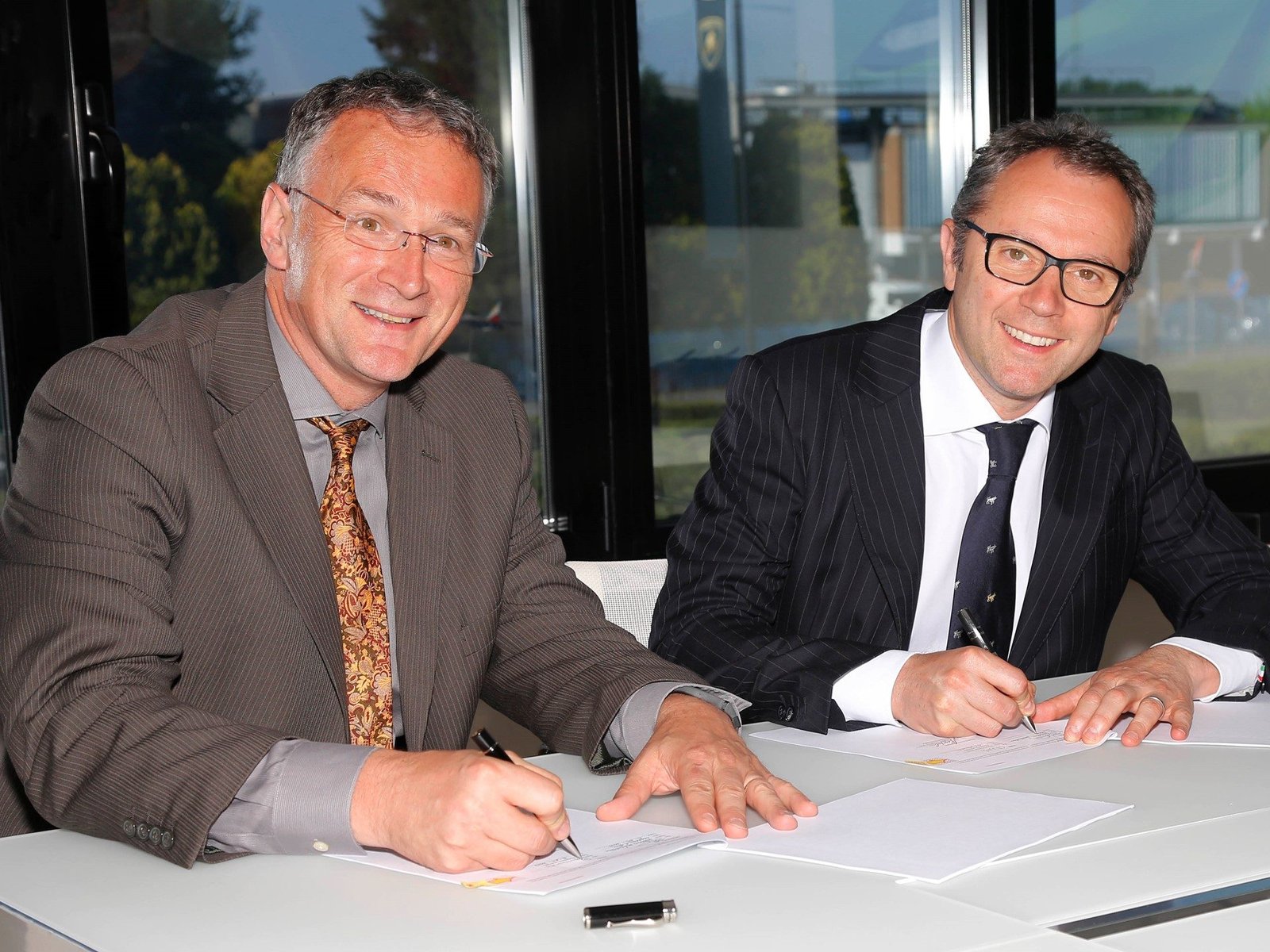 Stefano Domenicali and Mauro Ferrari signing the Lamborghini Houston Methodist carbon fiber research collaboration agreement at Sant'Agata Bolognese