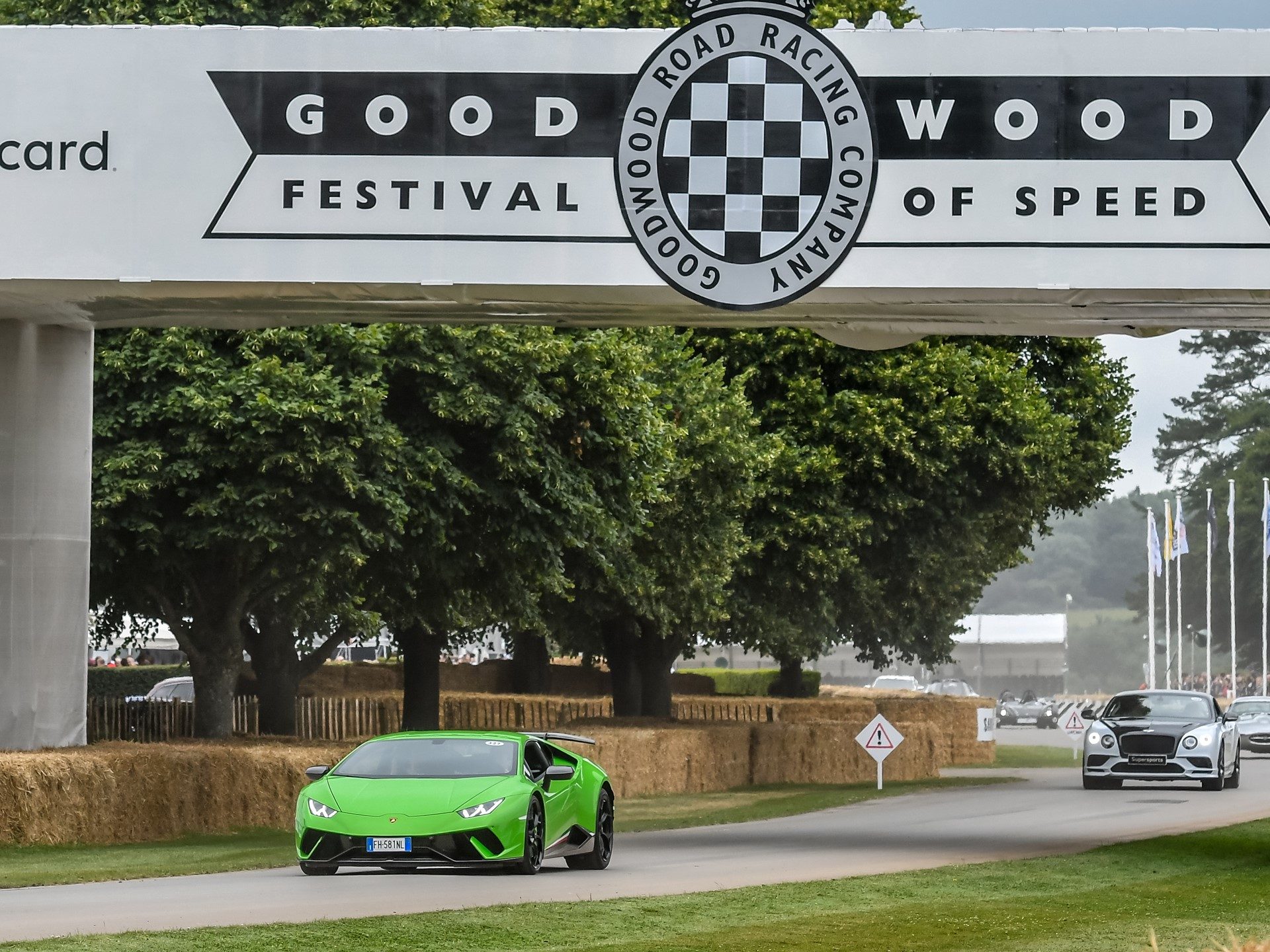 Green Lamborghini Huracán Performante driving up the hill at Goodwood Festival of Speed 2017 with hay bales lining the track